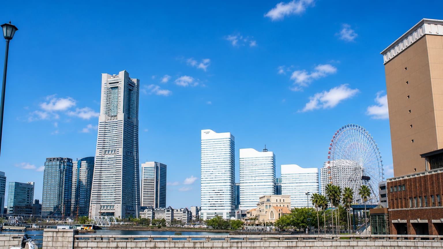 Yokohama Minato Mirai waterfront skyline with the Landmark Tower and Cosmo Clock 21 Ferris wheel under blue sky
