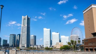 Yokohama Minato Mirai waterfront skyline with the Landmark Tower and Cosmo Clock 21 Ferris wheel under blue sky
