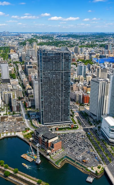 Kanagawa-ku, Yokohama: an aerial of the waterfront district with canals, a dark supertall tower and the harbour beyond