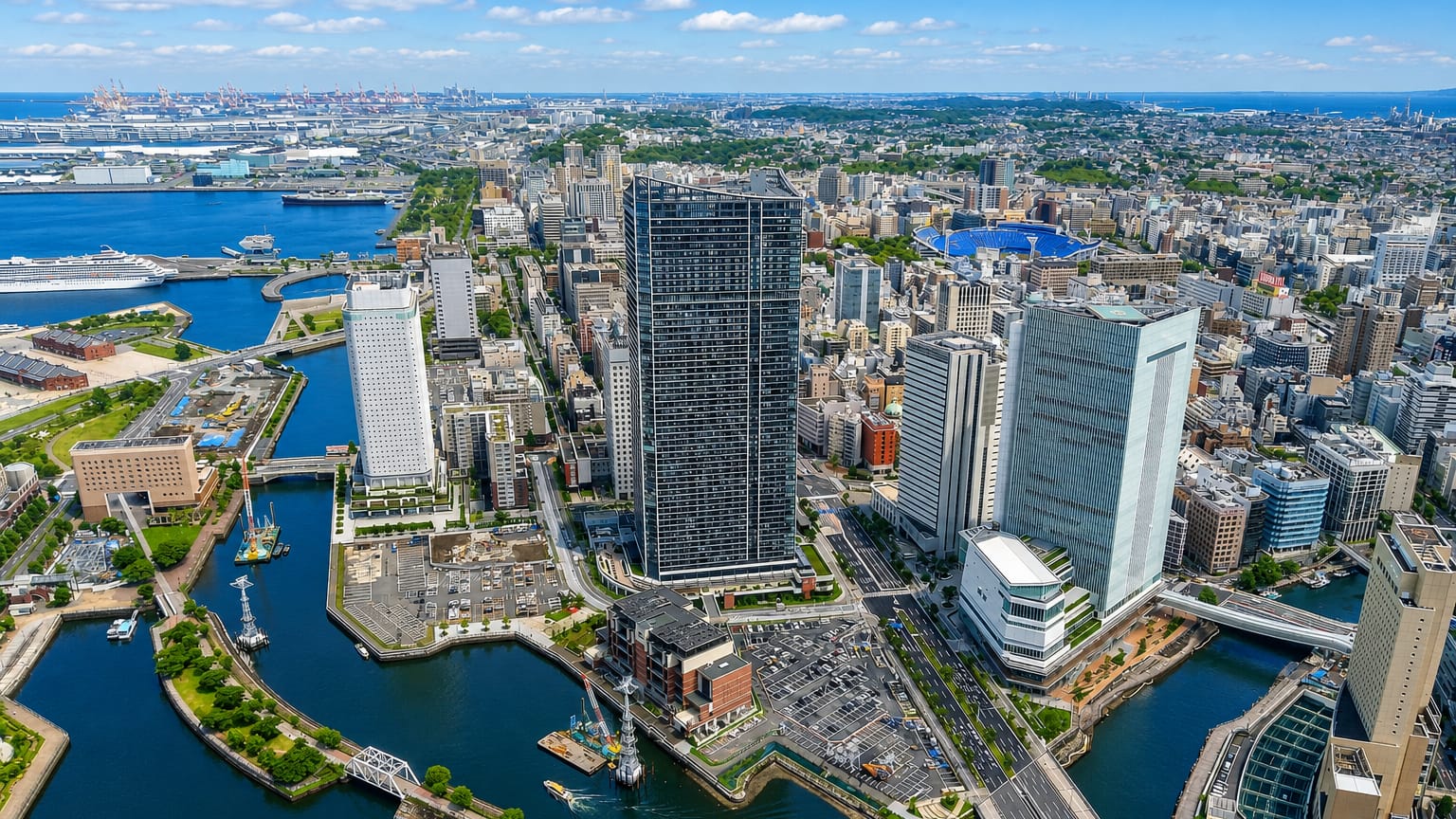 Kanagawa-ku, Yokohama: an aerial of the waterfront district with canals, a dark supertall tower and the harbour beyond