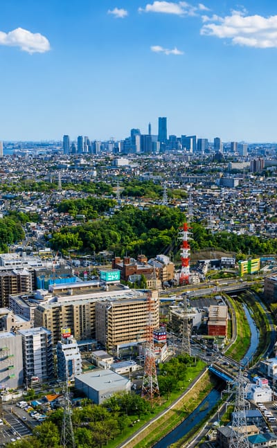 Aerial daytime view over the Kohoku-ku district of Yokohama with the Minato Mirai skyline on the horizon