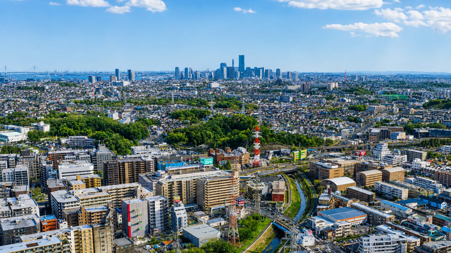 Aerial daytime view over the Kohoku-ku district of Yokohama with the Minato Mirai skyline on the horizon