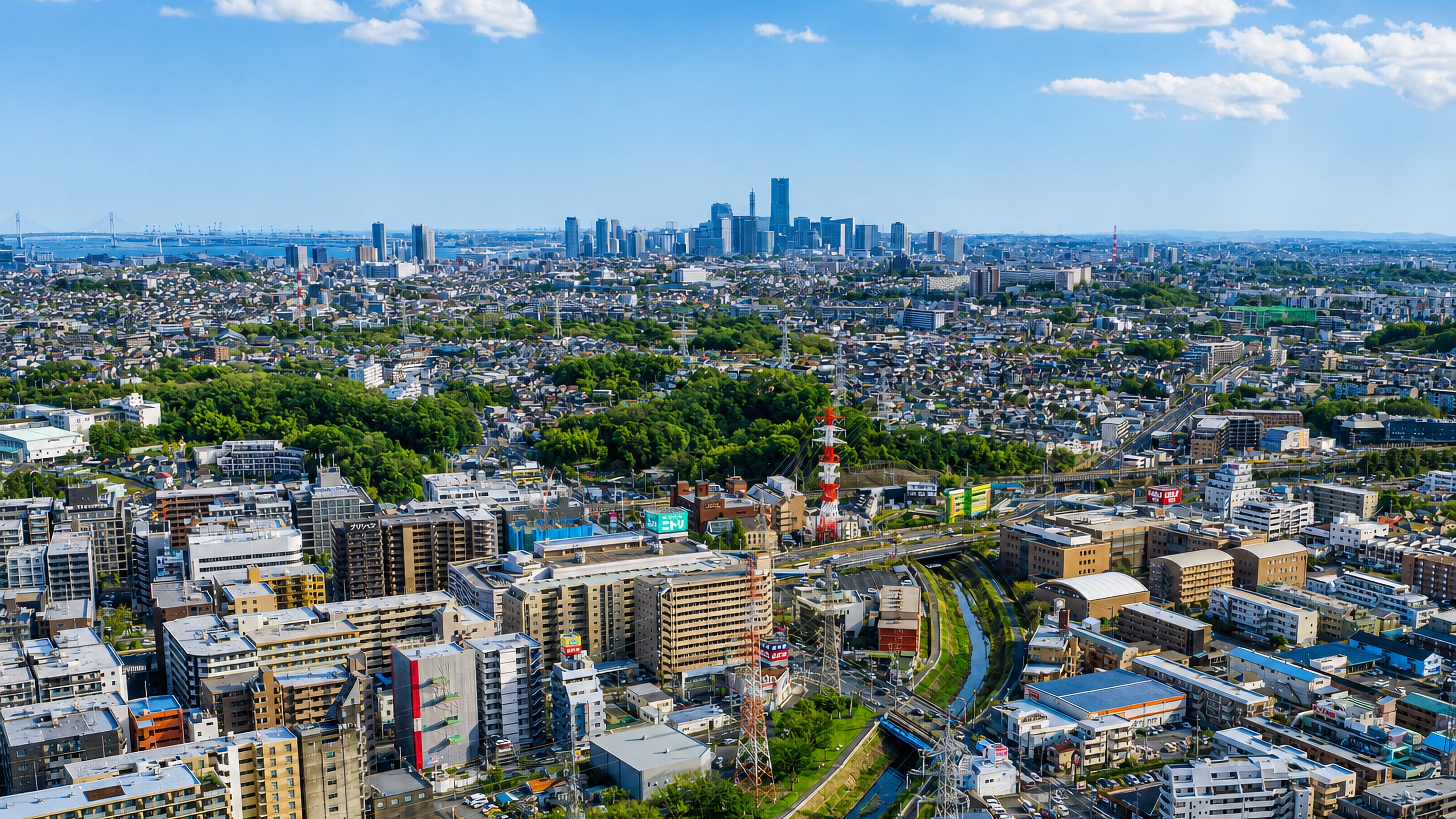 Aerial daytime view over the Kohoku-ku district of Yokohama with the Minato Mirai skyline on the horizon