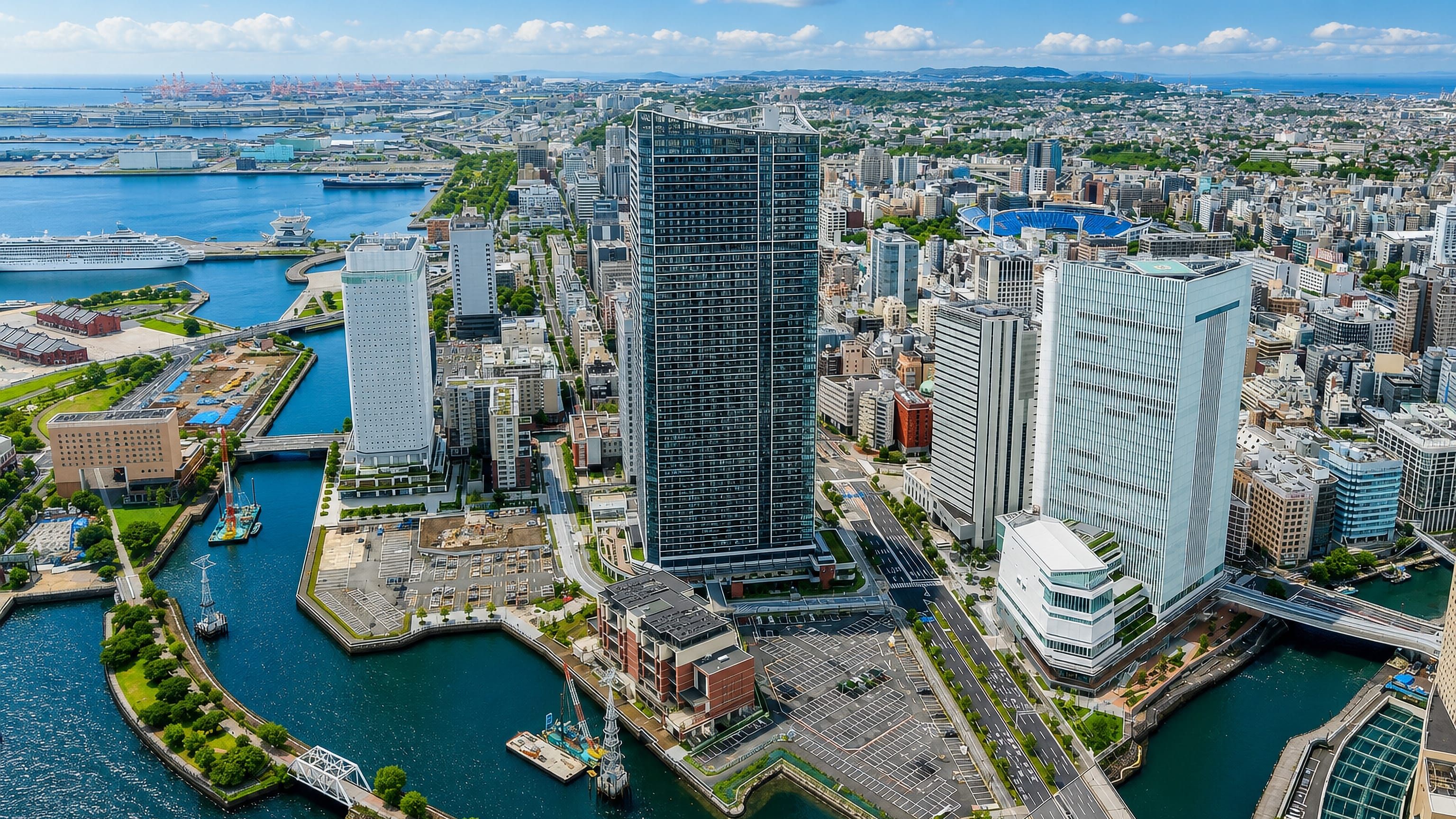 Yokohama's Naka-ku waterfront, with harbour canals, a cruise ship at the pier and the ballpark beyond.