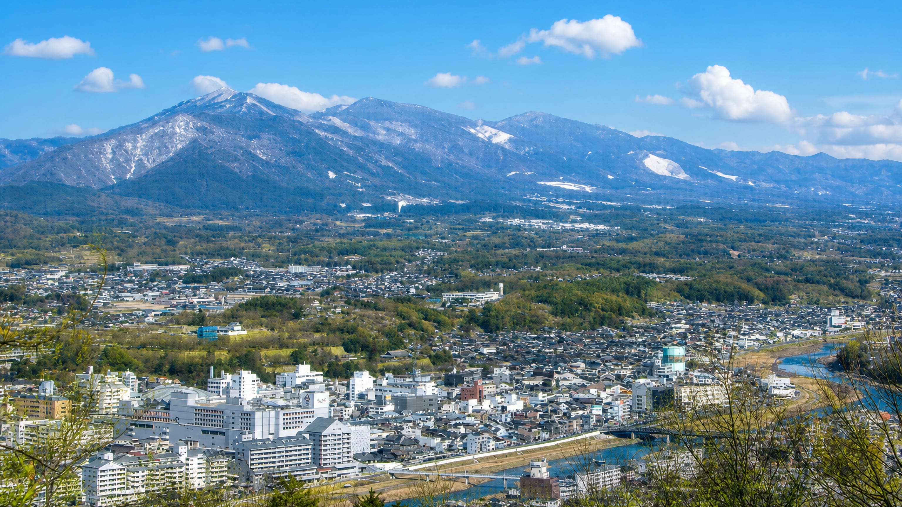 Tsuyama, Japan, spreads along its river in a valley below snow-streaked Chugoku mountains.