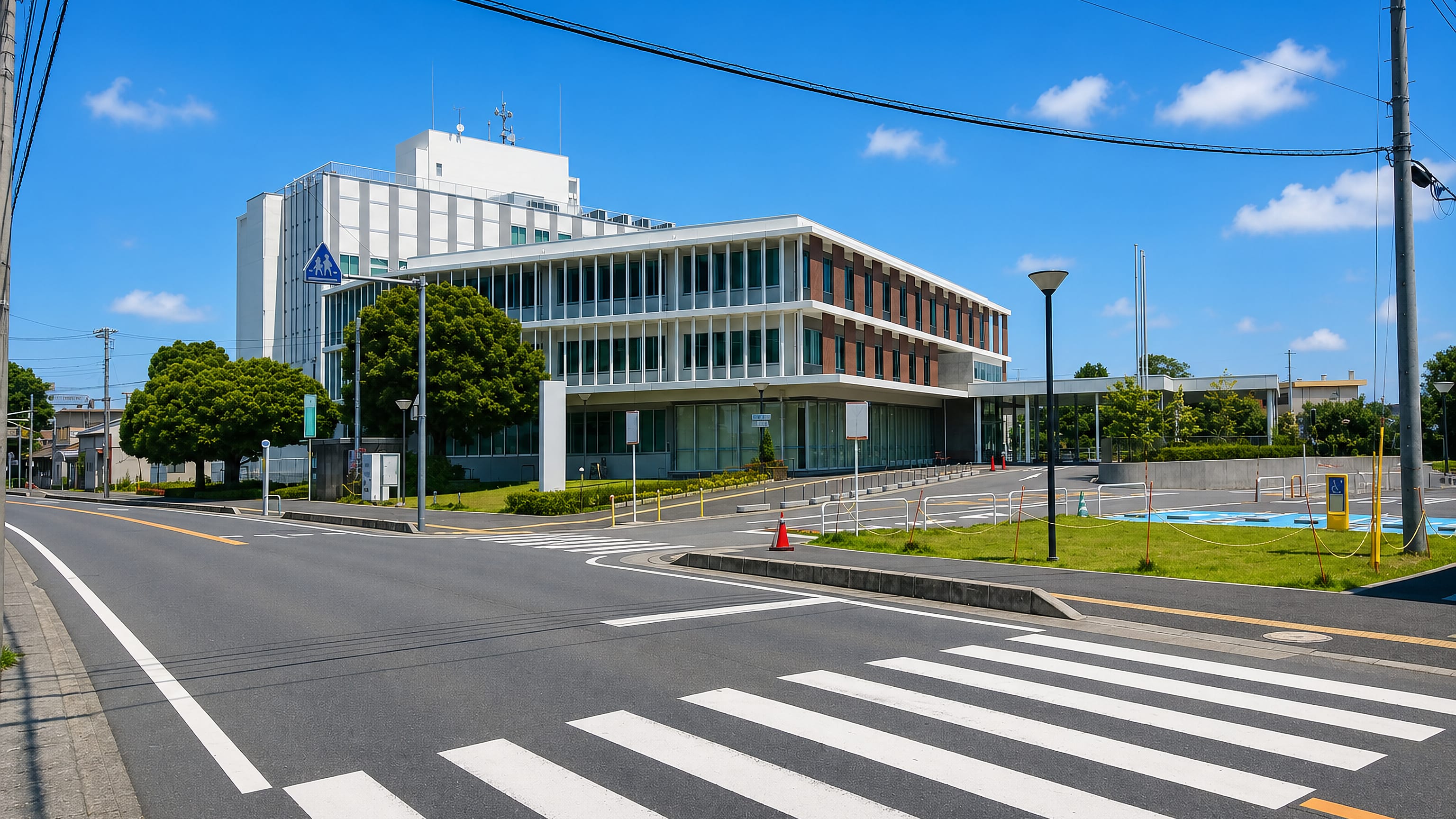 Modern civic building and wide crosswalk on a quiet street in Fujimino, Saitama, Japan.