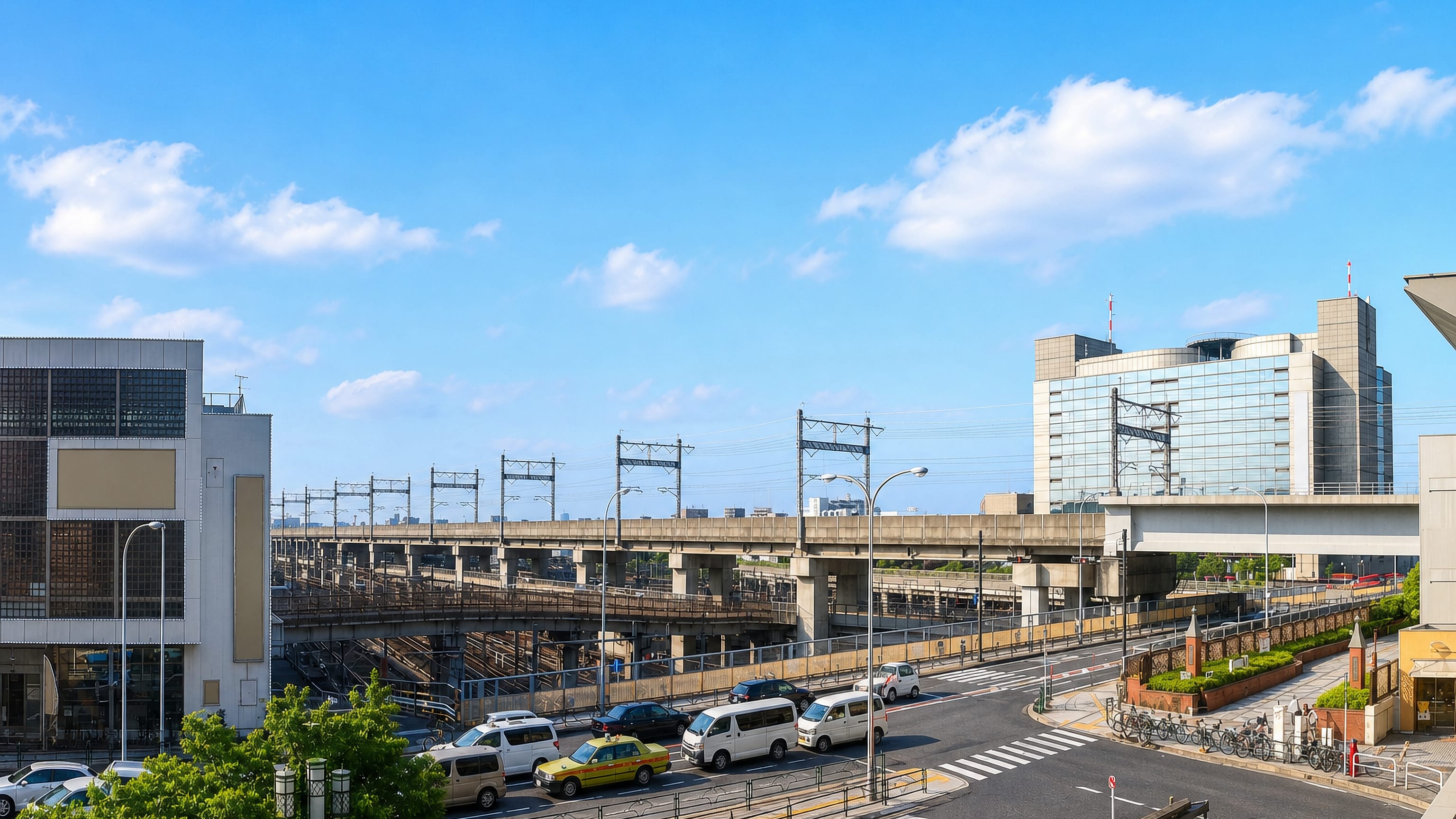 Elevated rail lines and a curved glass tower beside the station in Tabata, Kita, Tokyo.
