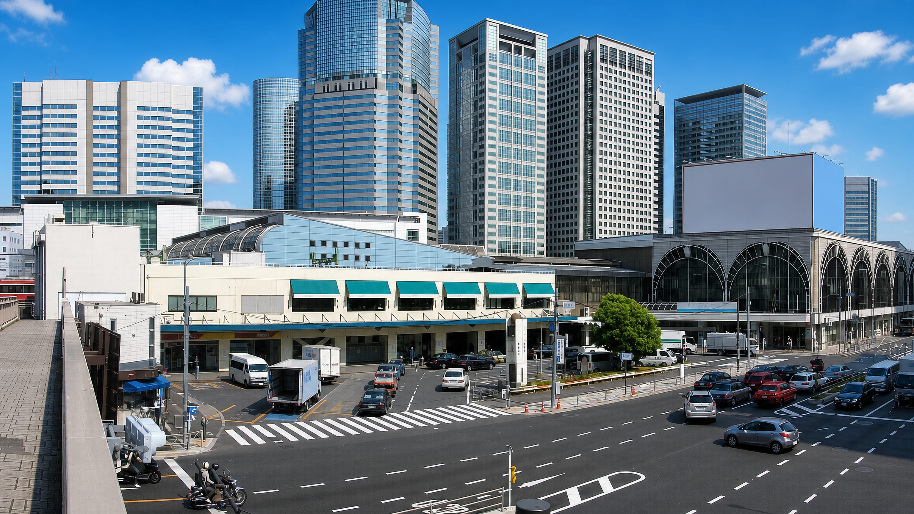 Glass office towers above a station forecourt and wide avenue in Takanawa, Minato City, Tokyo