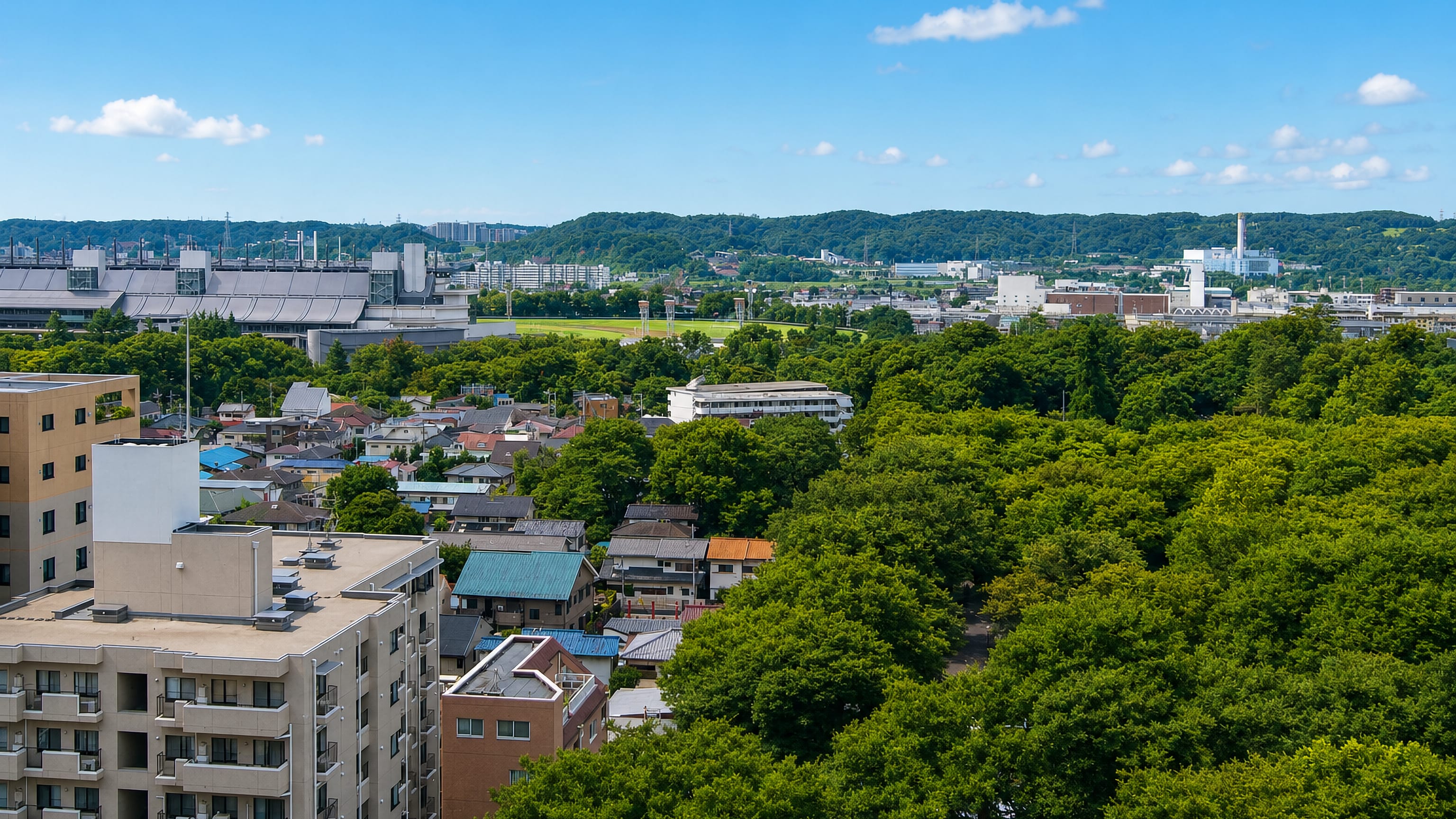 Elevated view over low-rise houses and leafy green streets of suburban Fuchū, western Tokyo.