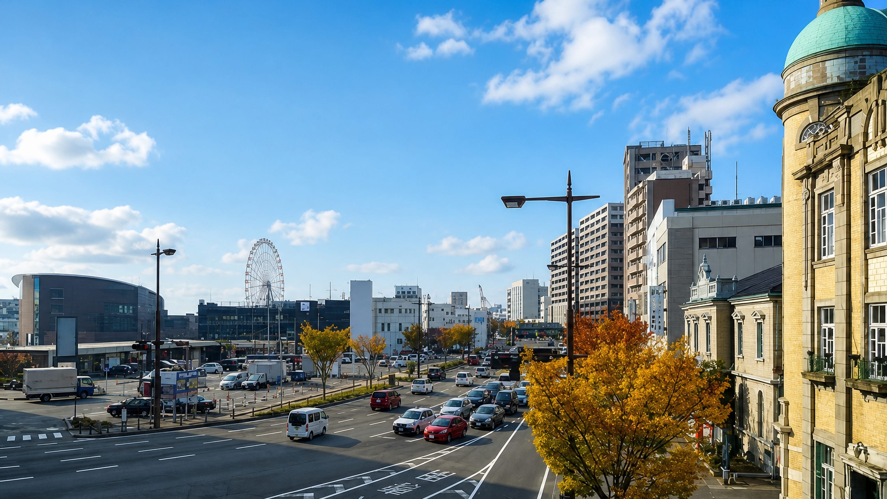 Wide daytime street in Shimonoseki, Japan, with a historic domed building, autumn trees and a distant Ferris wheel