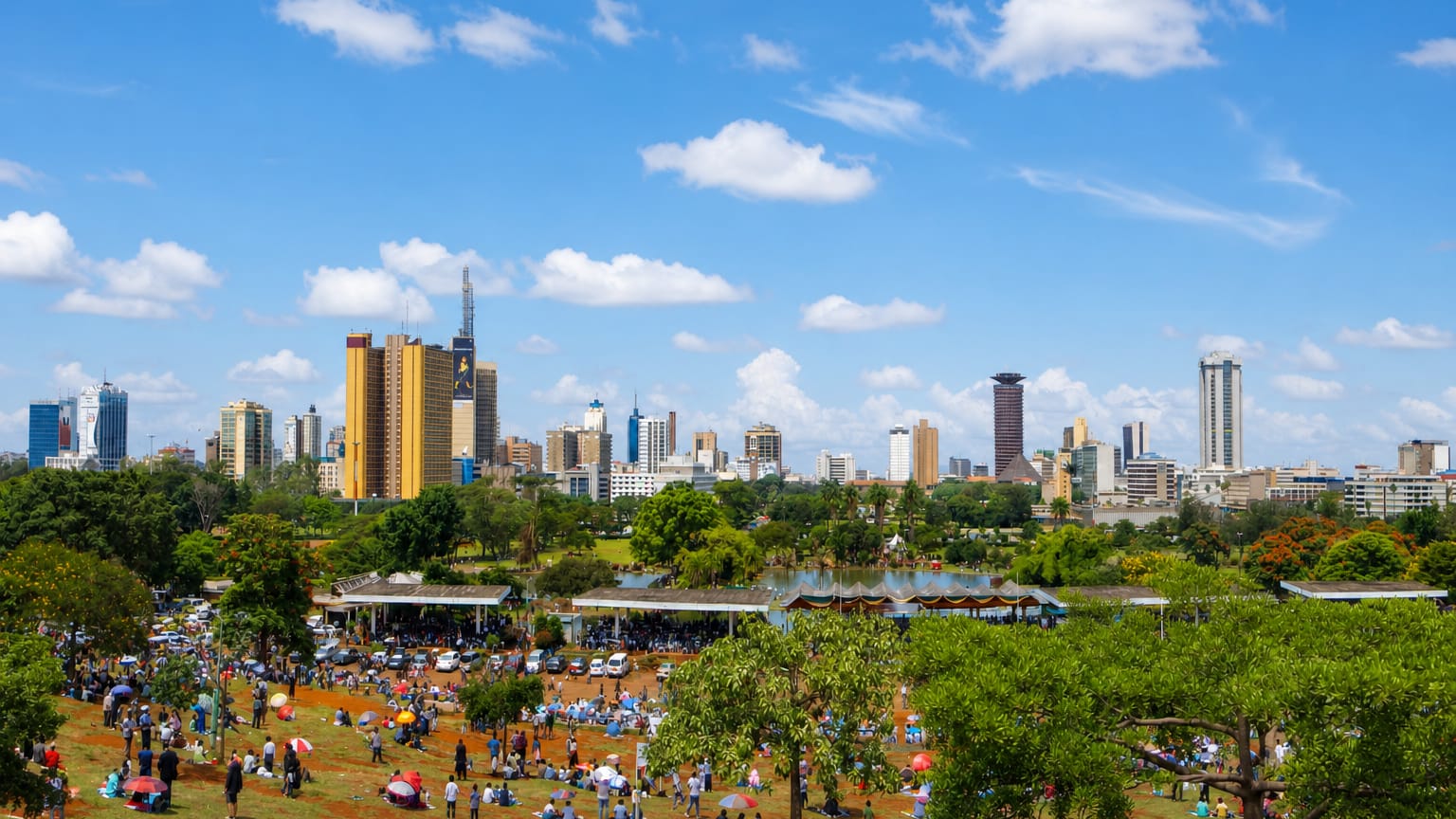 Nairobi skyline with the cylindrical Kenyatta International Convention Centre tower seen across a green park.