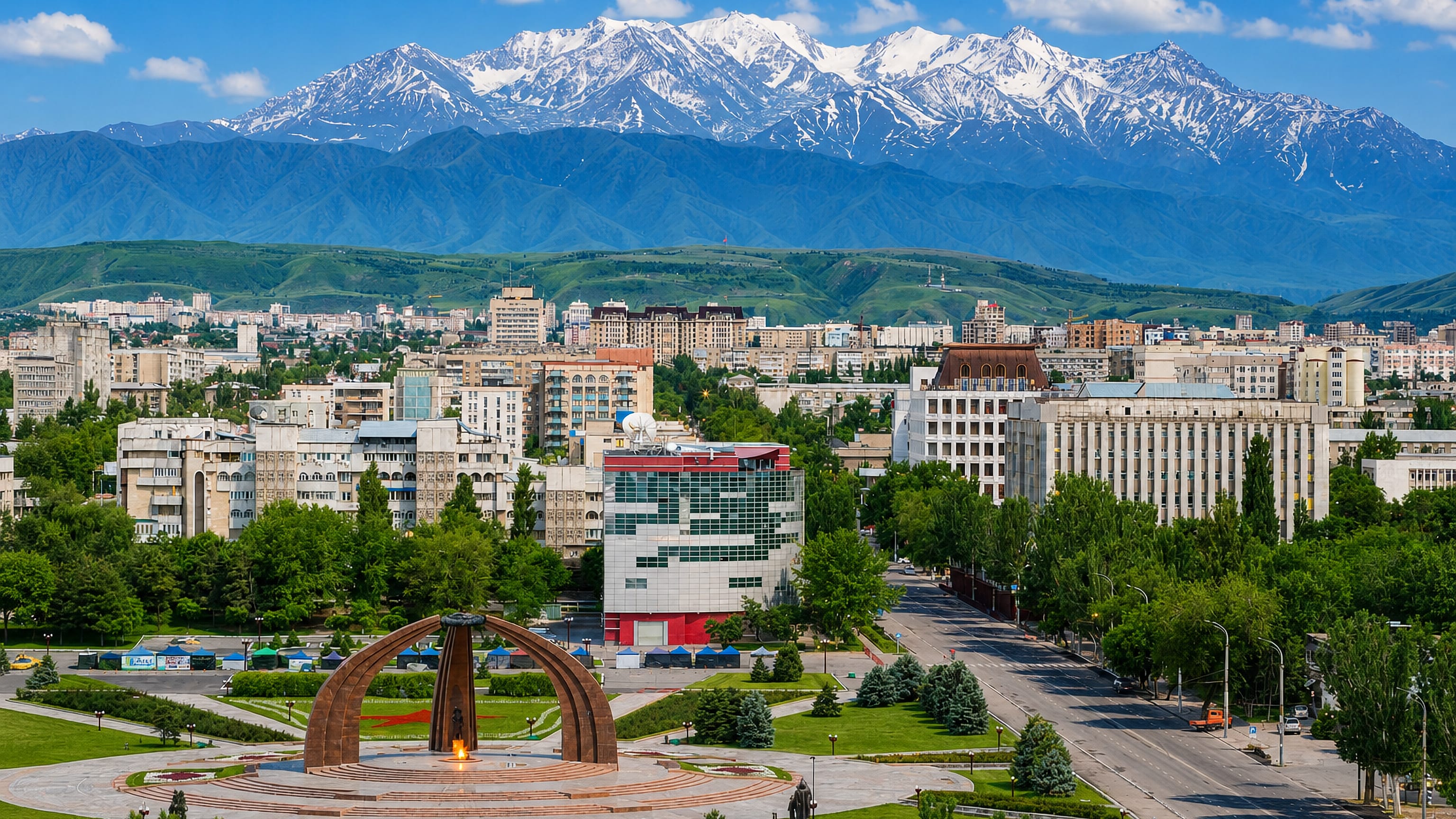 Bishkek's Victory Square monument and eternal flame below the snow-capped Kyrgyz Ala-Too range