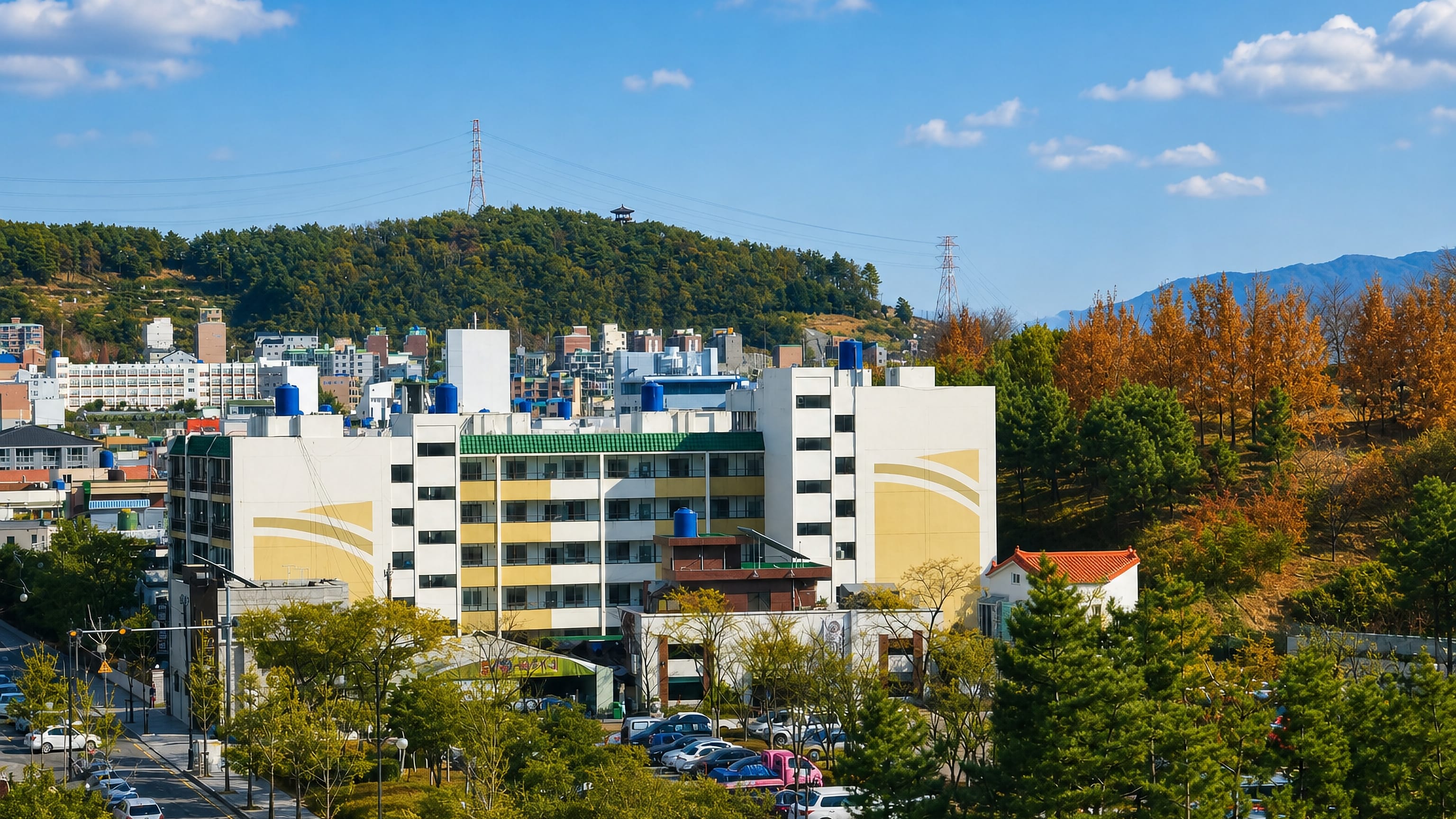 Mid-rise apartment blocks and autumn trees below a forested hill in Kimhae (Gimhae), South Korea