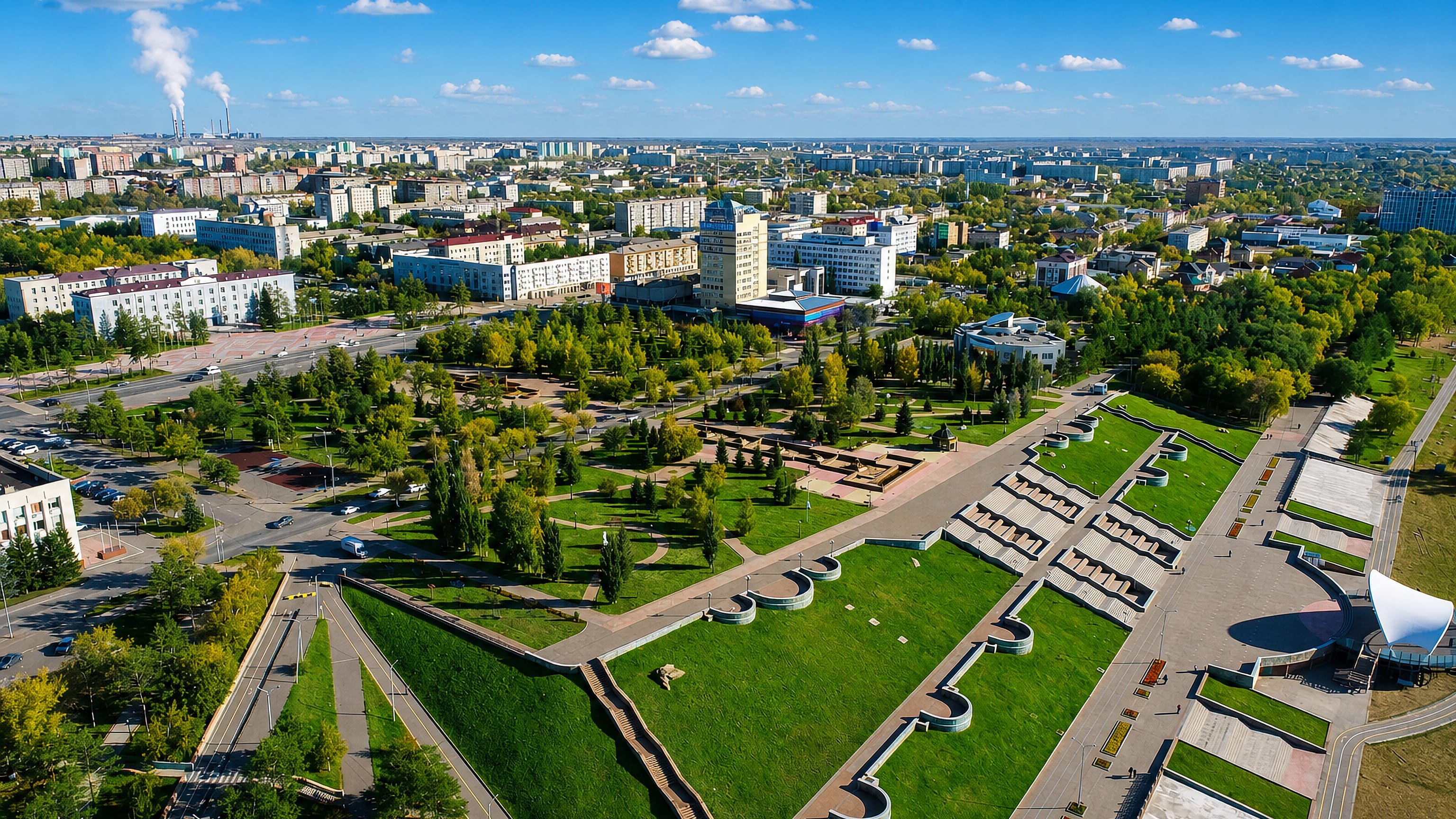 Aerial view of Pavlodar, Kazakhstan, its riverside park terraces, wide boulevards and Soviet-era blocks.