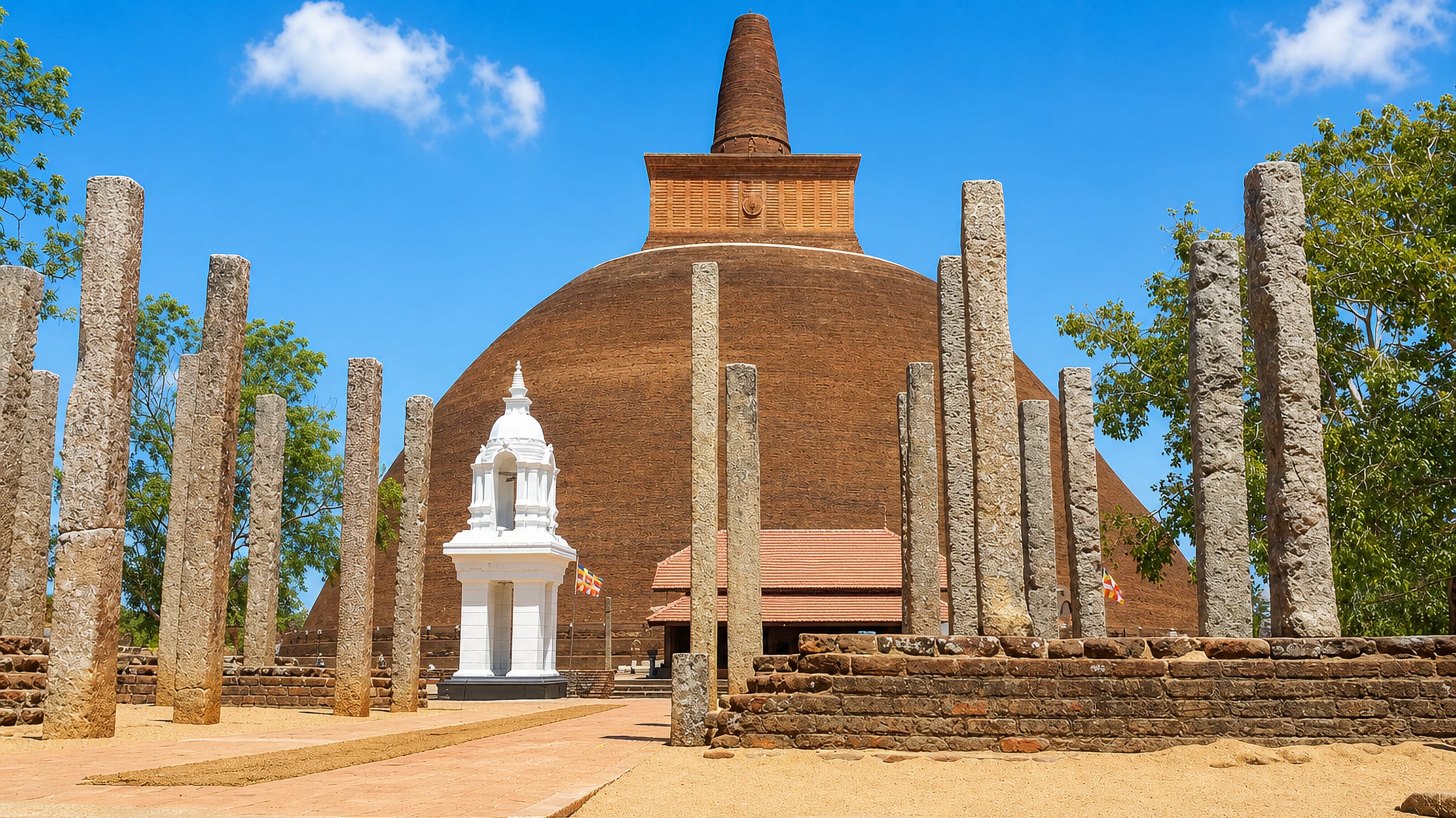 Brick dagoba rising above rows of ancient stone pillars at the sacred city of Anuradhapura, Sri Lanka.
