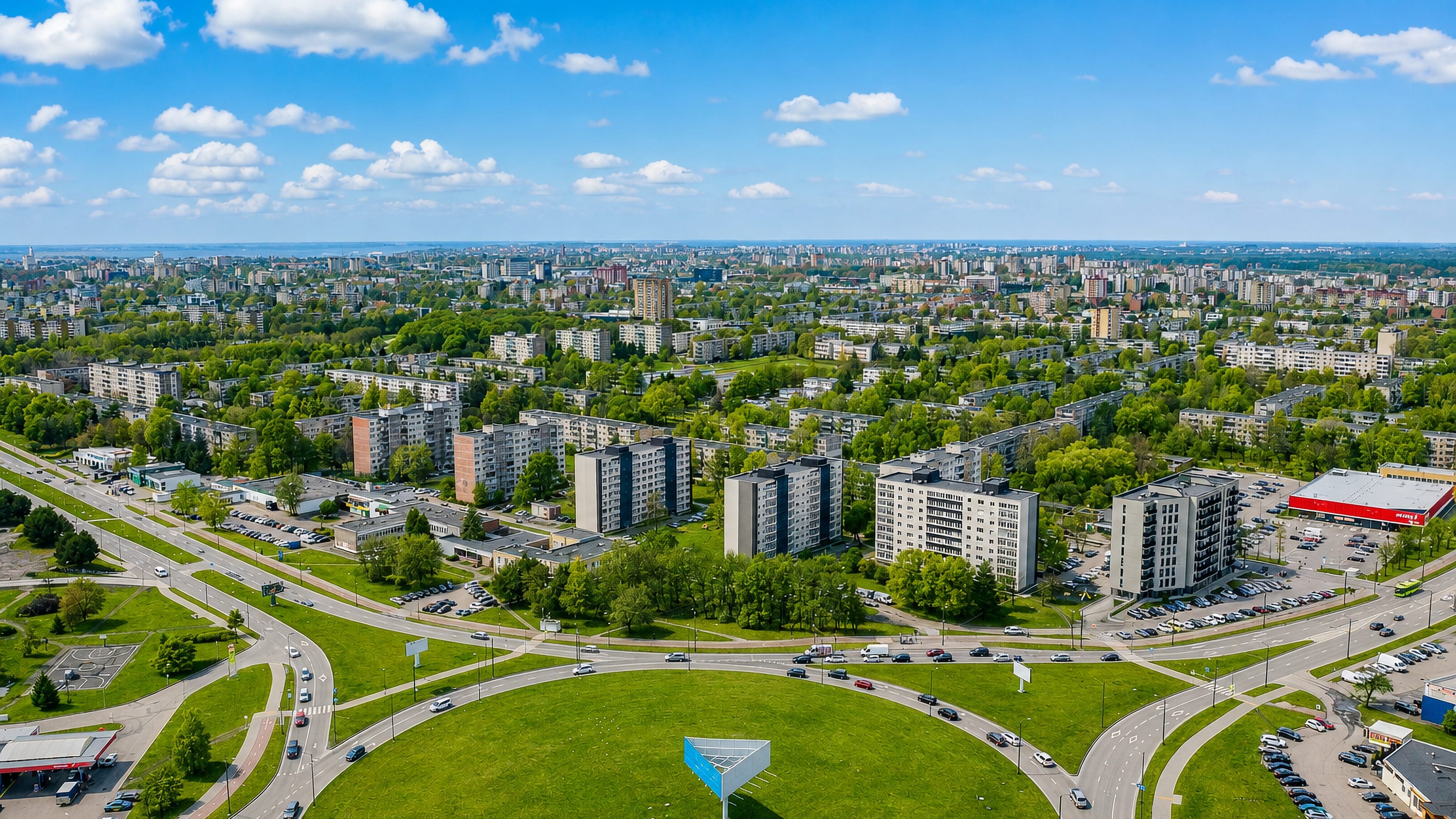 Aerial view of Dainava in Kaunas, with mid-rise apartment blocks around a broad grassy roundabout.