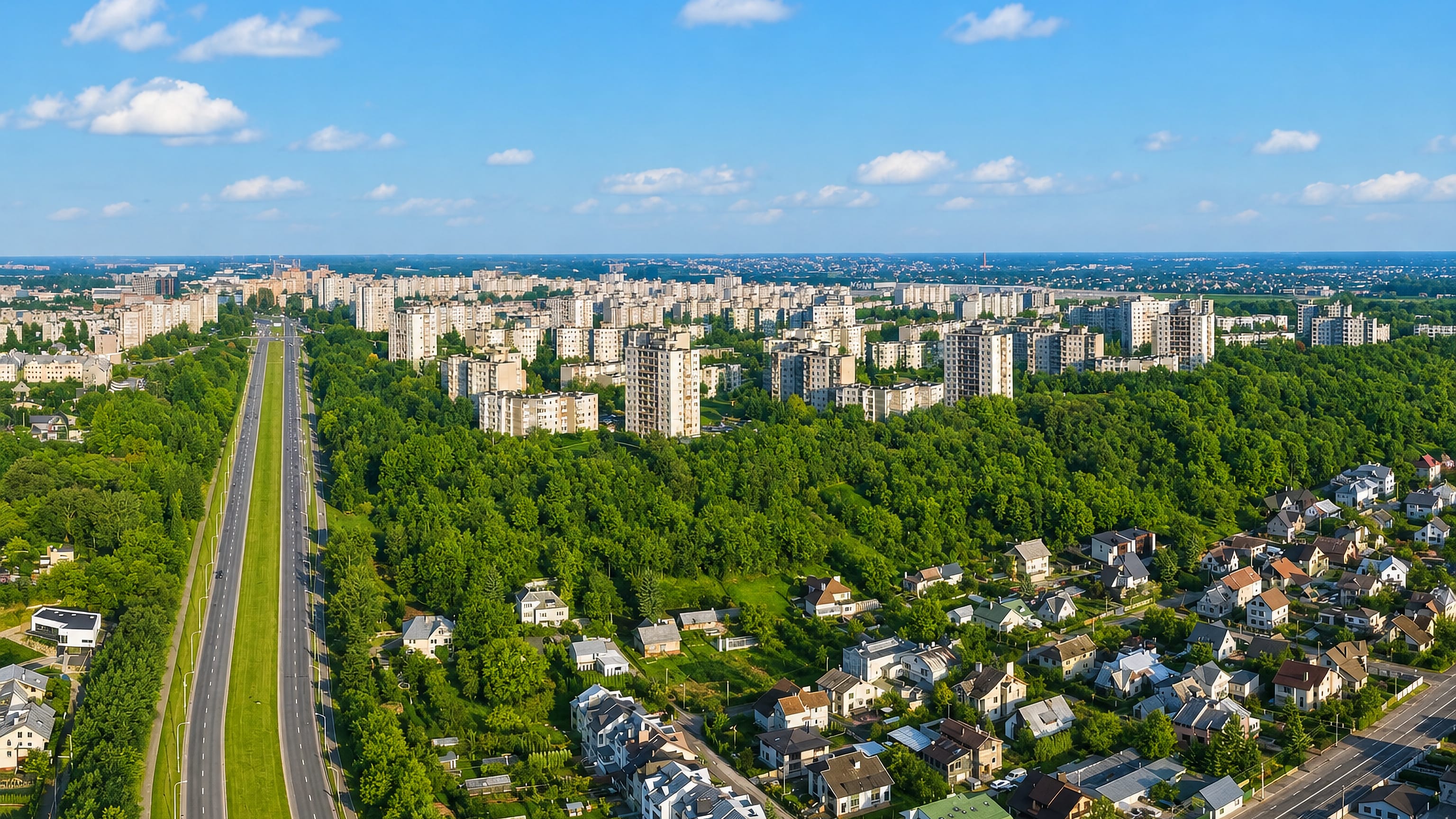 Aerial view of Šilainiai in Kaunas, its apartment blocks and woodland flanking a broad highway.