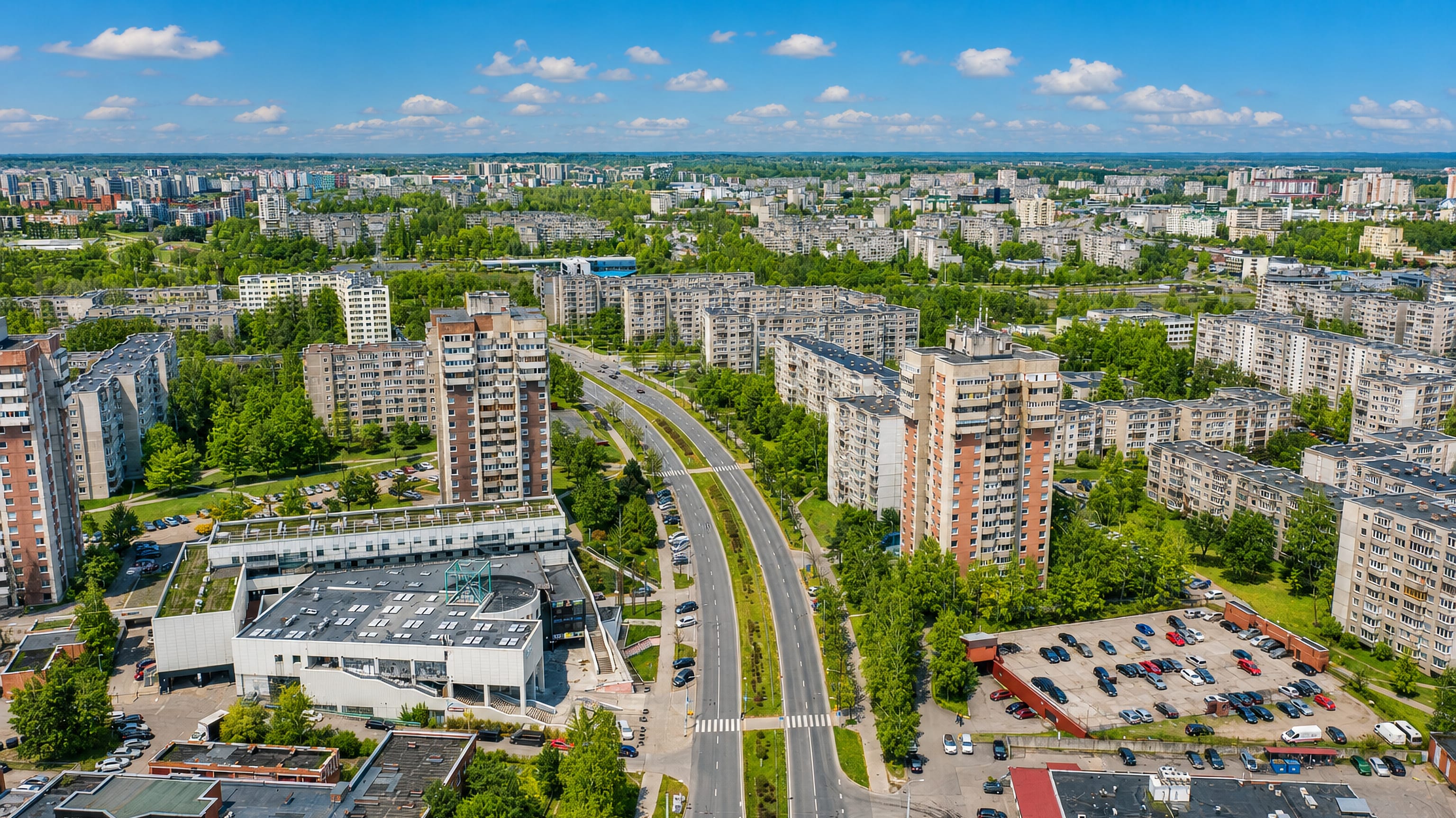 Aerial view over Justiniškės in Vilnius, panel apartment blocks lining a wide tree-edged boulevard