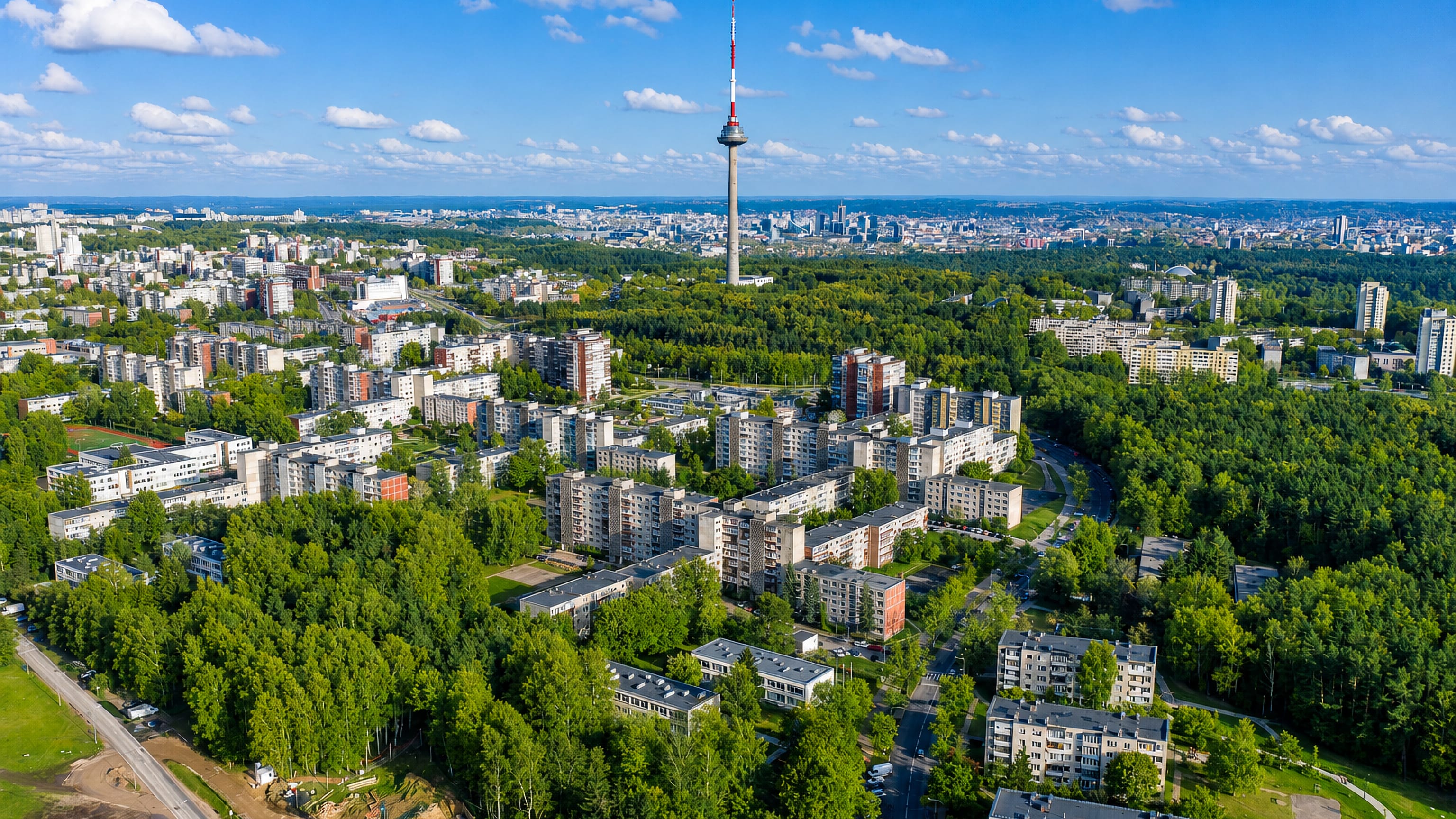 Aerial view over Karoliniškės, Vilnius, with Soviet-era apartment blocks, dense woodland and the Vilnius TV Tower.