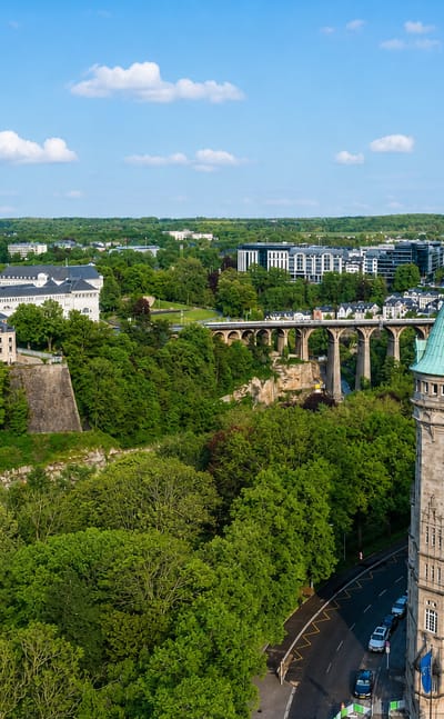 Aerial view of Luxembourg City with the green-domed Spuerkeess bank tower and the Pfaffenthal viaduct over wooded valleys