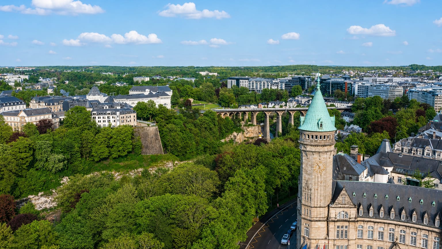 Aerial view of Luxembourg City with the green-domed Spuerkeess bank tower and the Pfaffenthal viaduct over wooded valleys