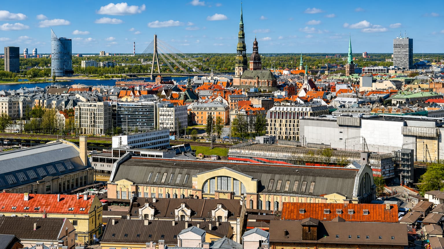 Aerial view of Riga's old town with St Peter's spire, the Central Market halls and the Vansu Bridge