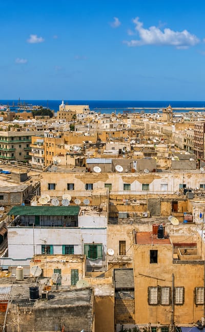 Rooftop panorama over Tripoli's old city and mosque minaret toward the Mediterranean port