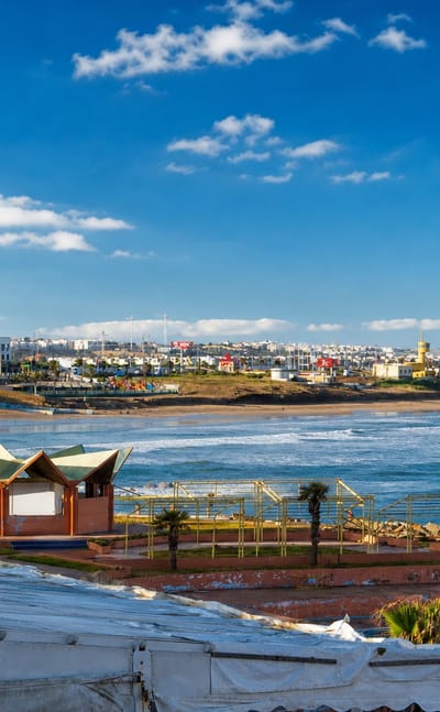 Ain Diab, Casablanca: the Atlantic corniche with a beachfront promenade, waves and the low white city skyline beyond