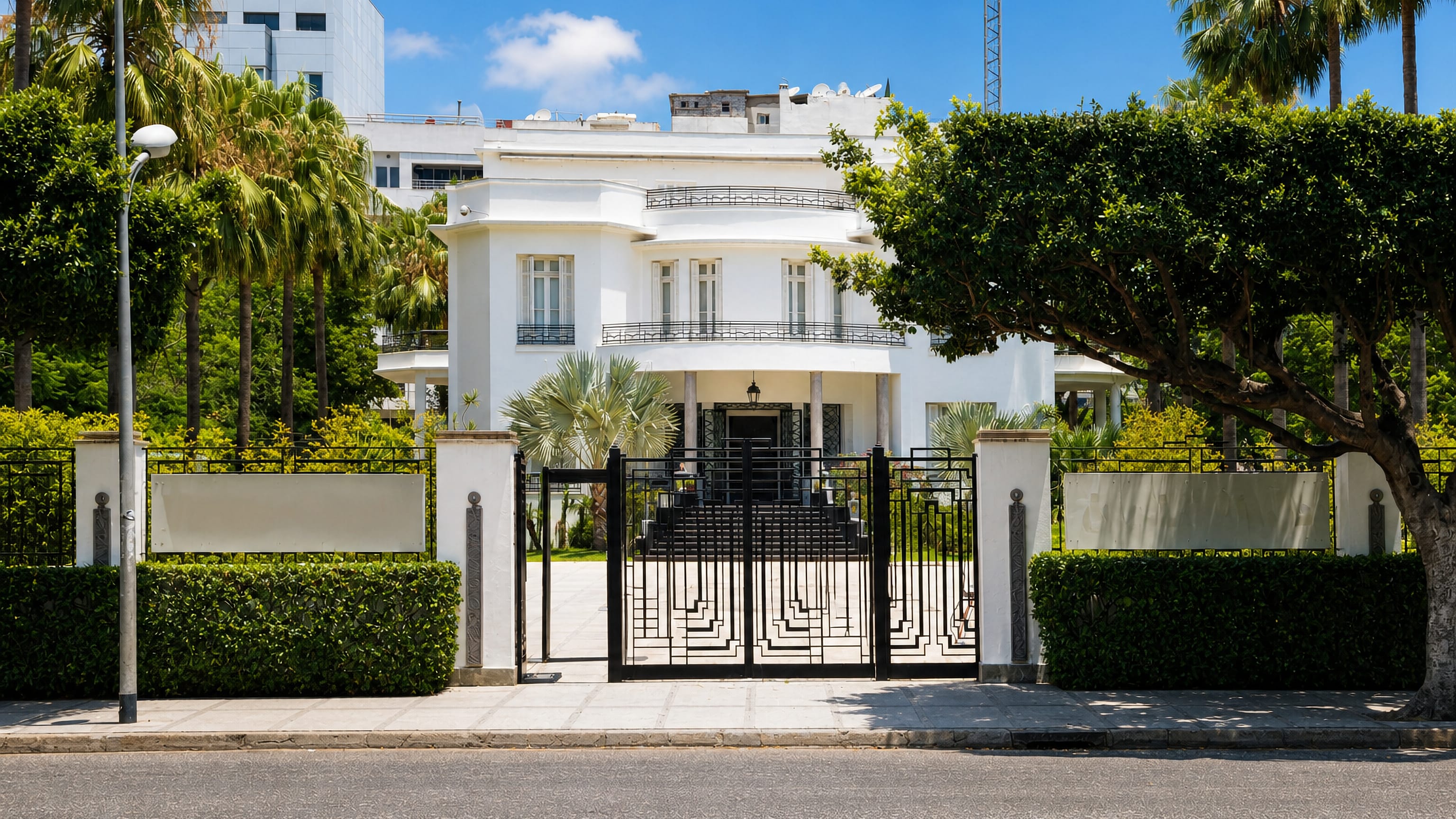 White Art Deco villa behind iron gates and palms in Gauthier, Casablanca's early-20th-century villa quarter.