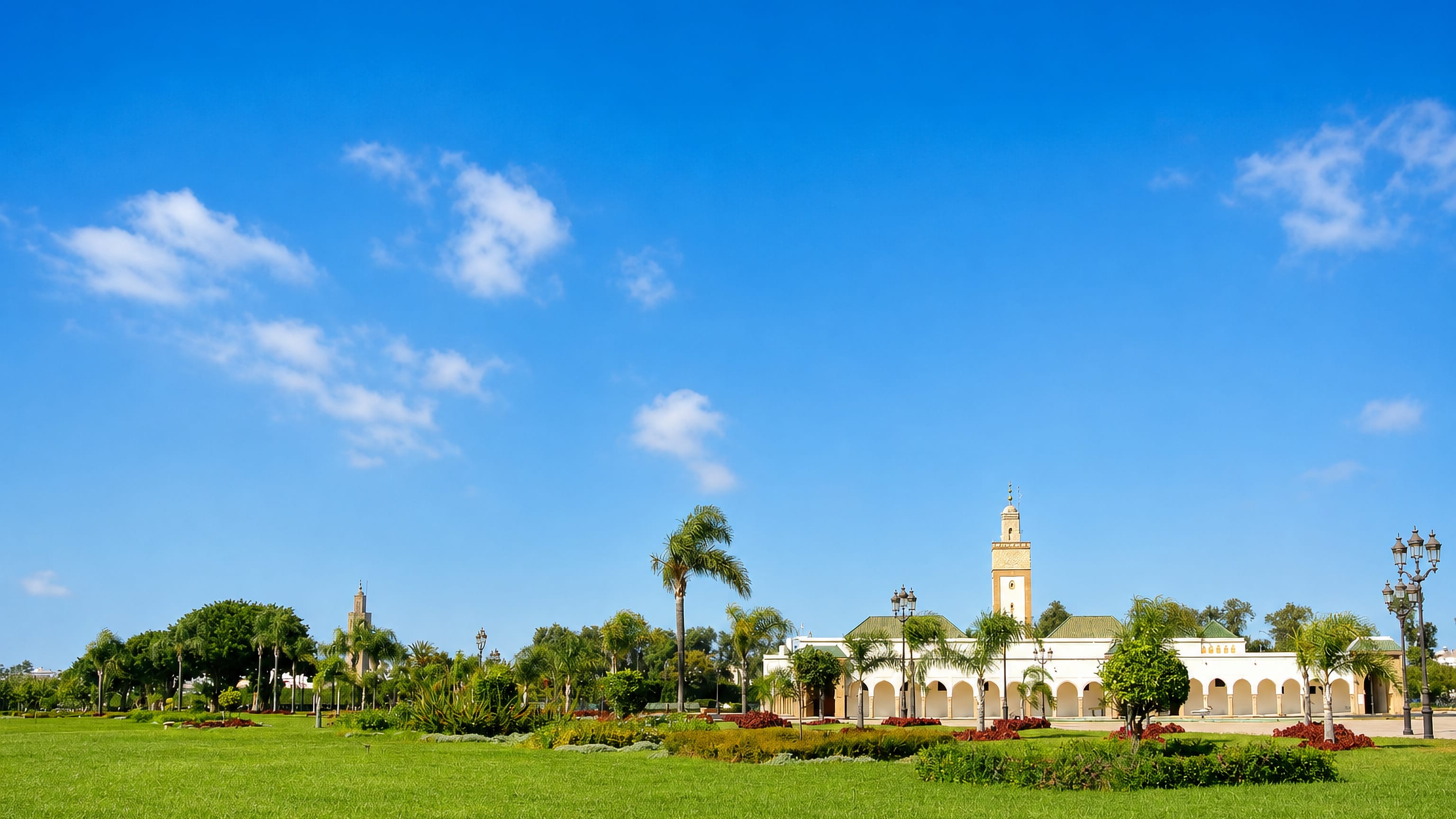 The arcaded Royal Palace and its minaret across the wide lawns of Touarga in Rabat