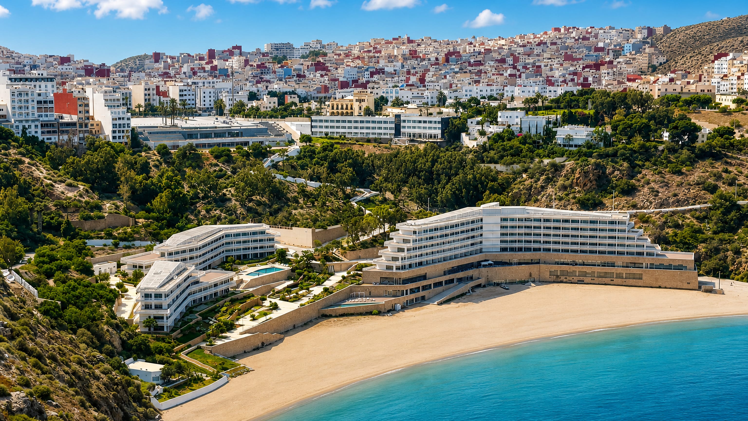 Quemado beach at Al Hoceima, Morocco, with a shoreline hotel and the white hillside town above the bay.
