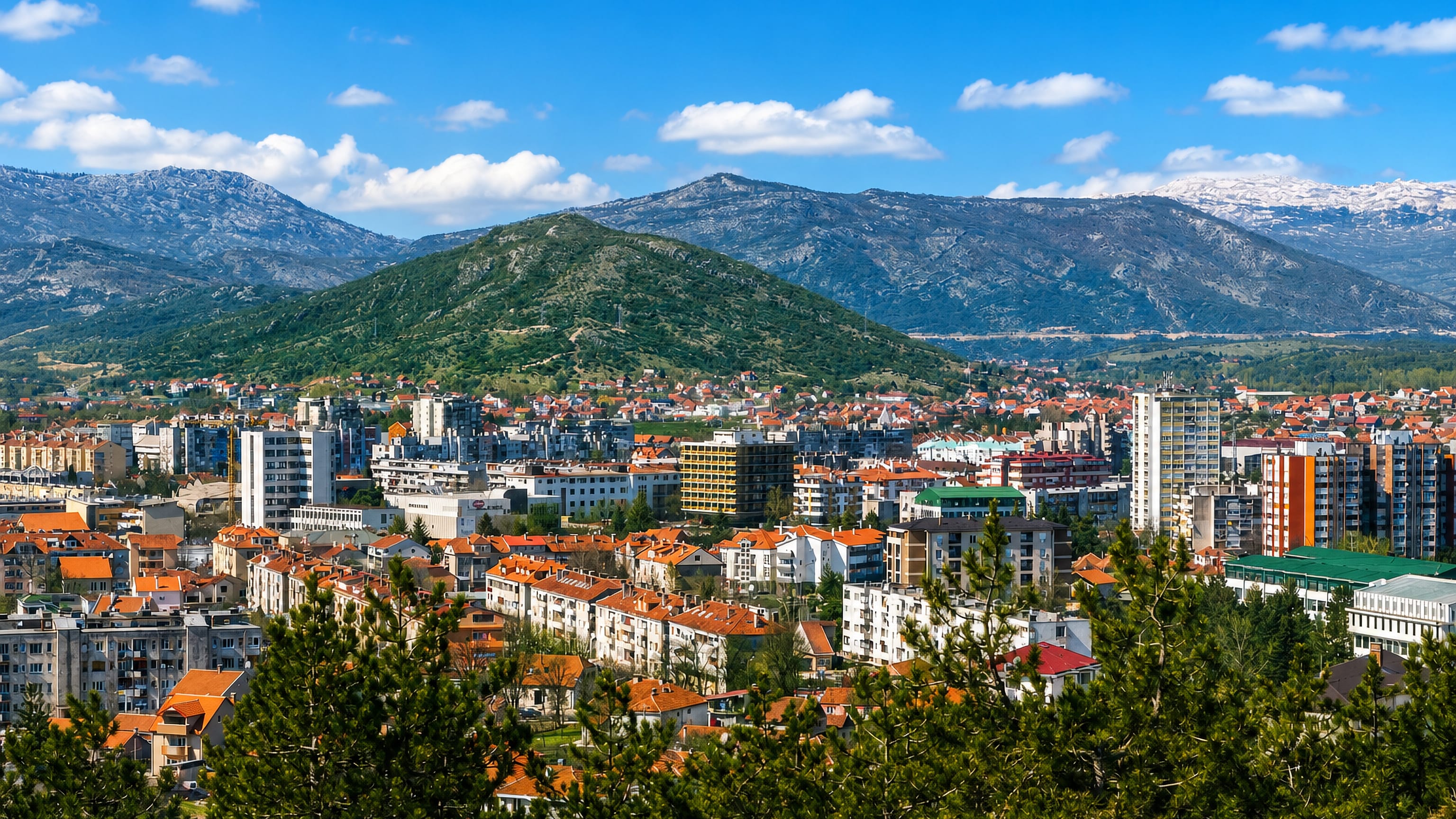 Nikšić's red-roofed houses and apartment blocks on the plain below Montenegro's mountain ridges.