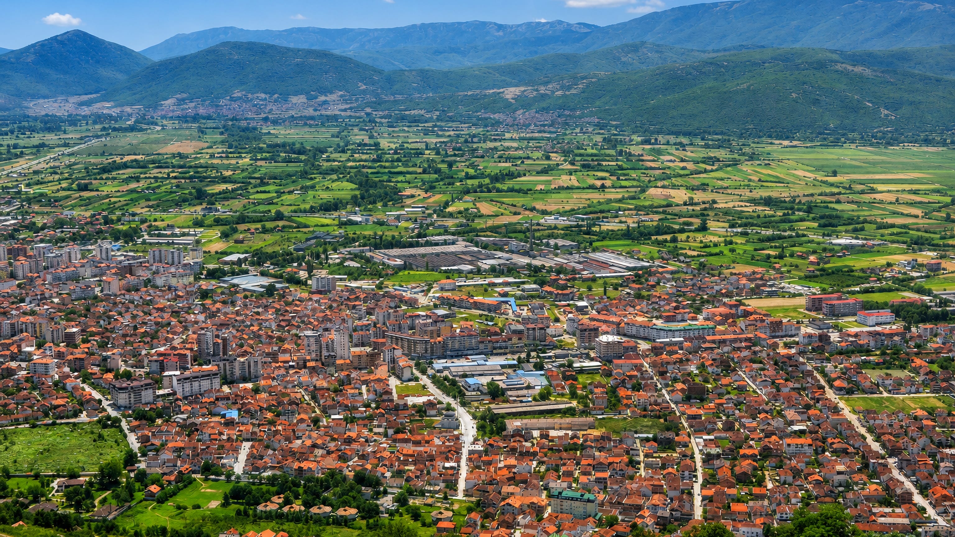 Tetovo's red-roofed sprawl across the green Polog valley below the Šar Mountains, North Macedonia.