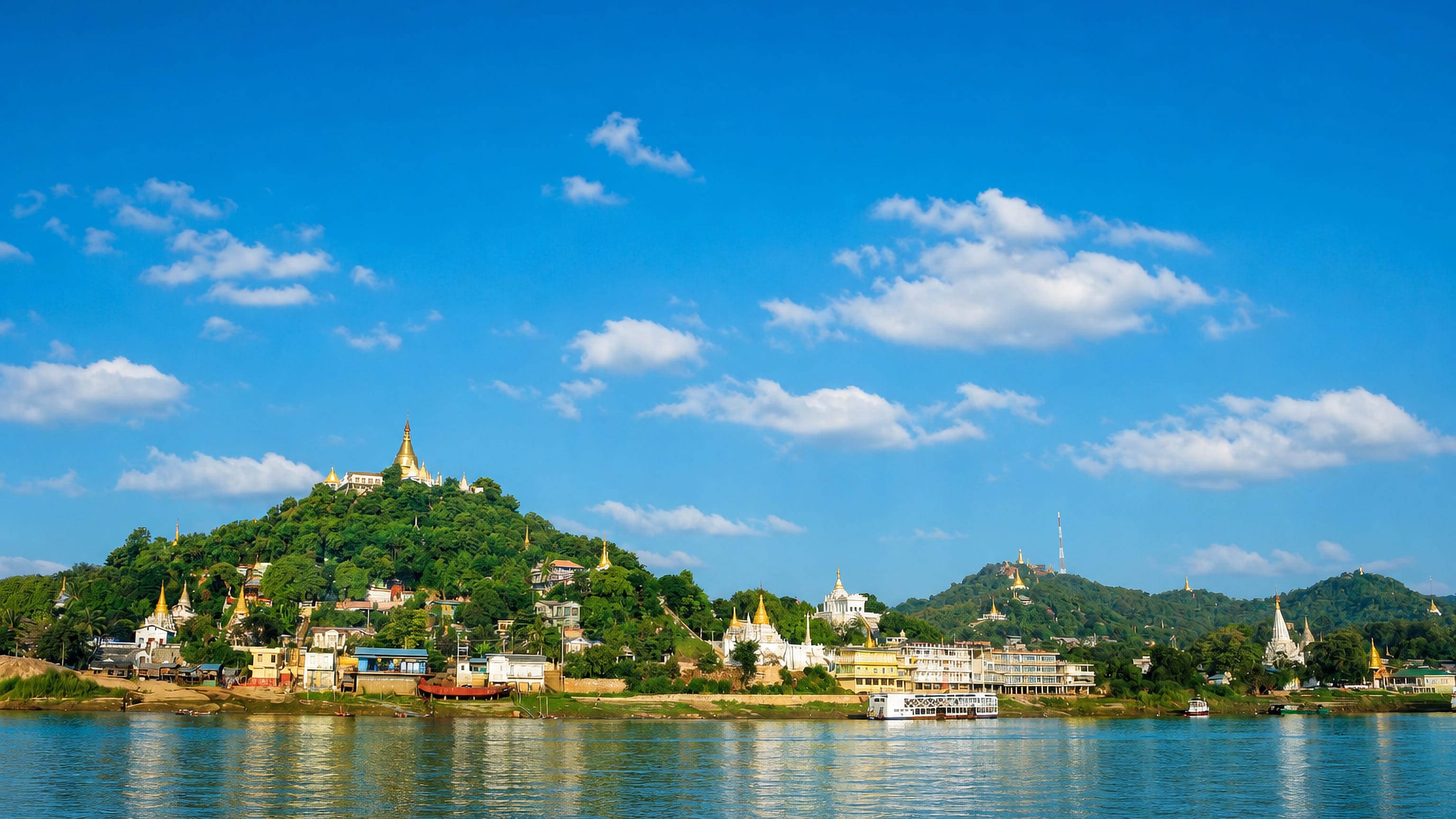 Sagaing Hill's white and gold pagodas rising above the Irrawaddy River waterfront at Sagaing