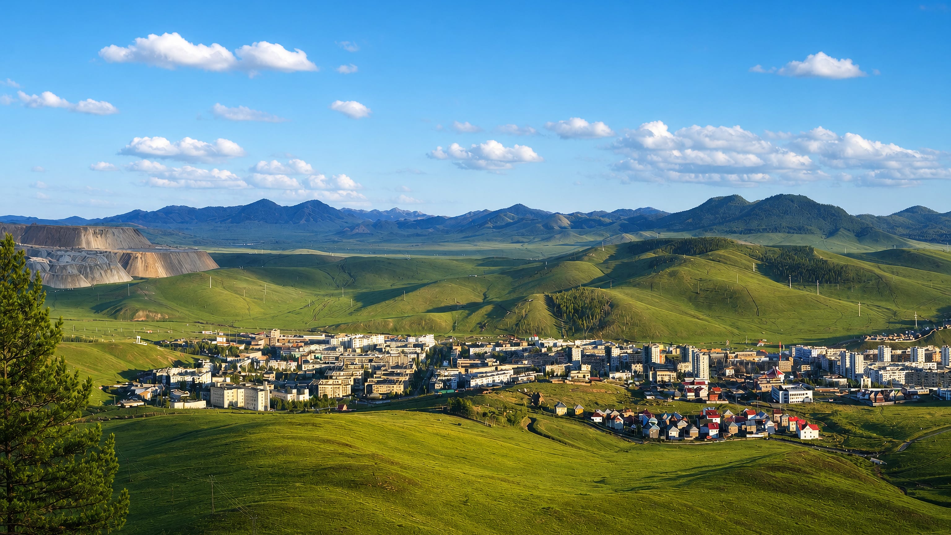 Erdenet, Mongolia, its apartment blocks in a green valley below the terraced copper-mine spoil heaps.
