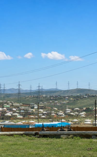 Hillside ger district of white yurts and small houses under power lines in Songino Khairkhan, Ulaanbaatar.