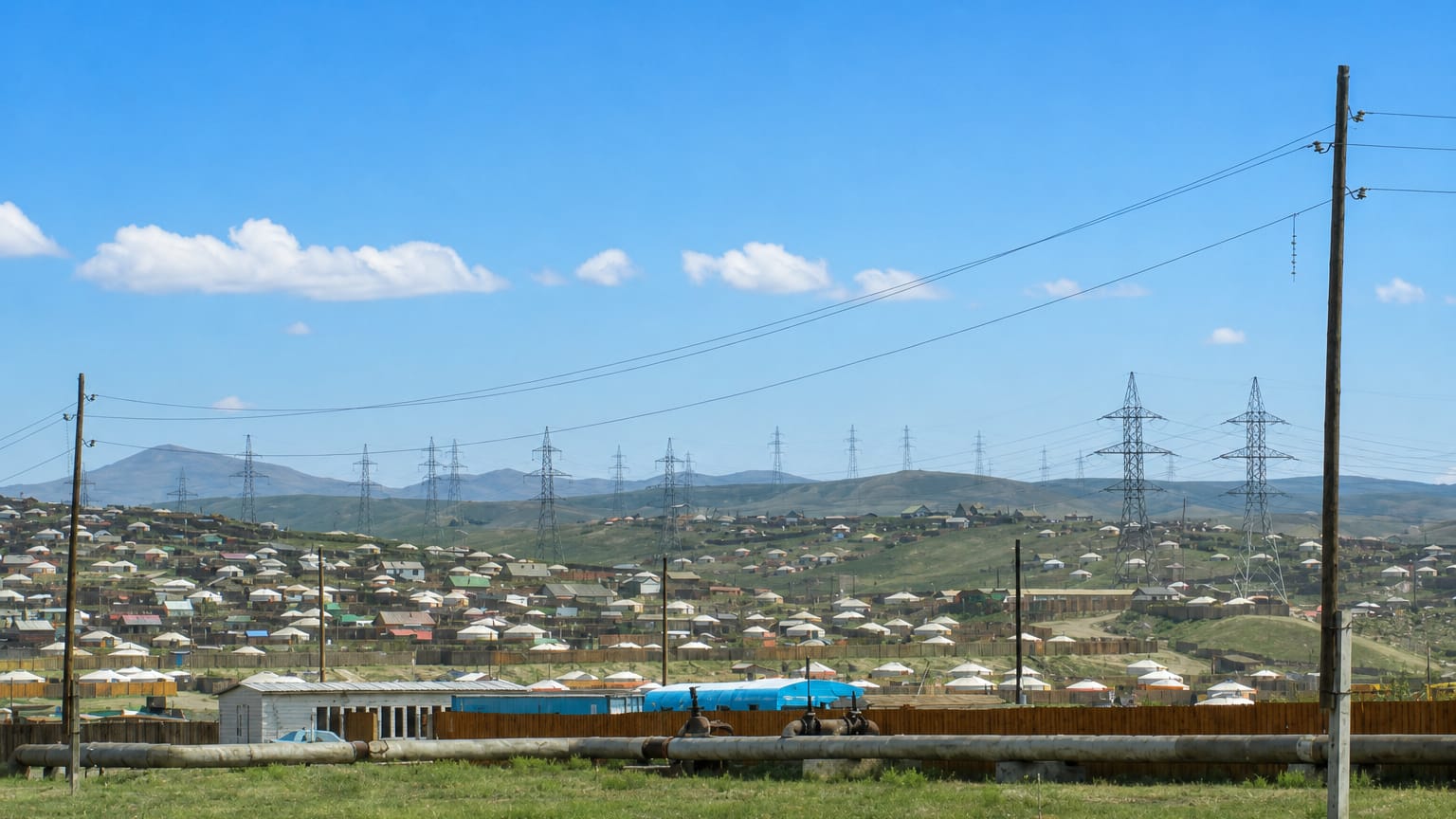 Hillside ger district of white yurts and small houses under power lines in Songino Khairkhan, Ulaanbaatar.