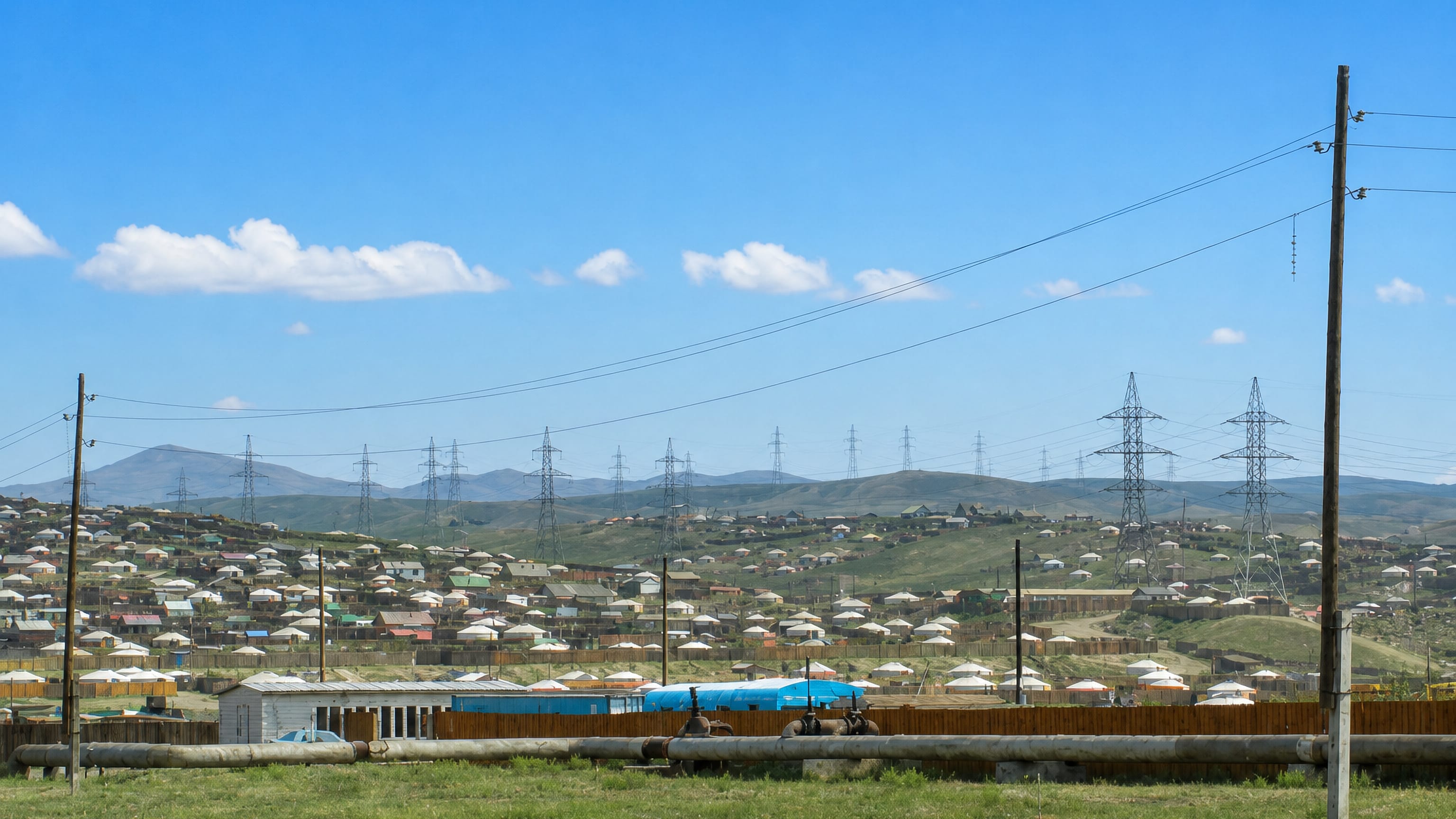 Hillside ger district of white yurts and small houses under power lines in Songino Khairkhan, Ulaanbaatar.