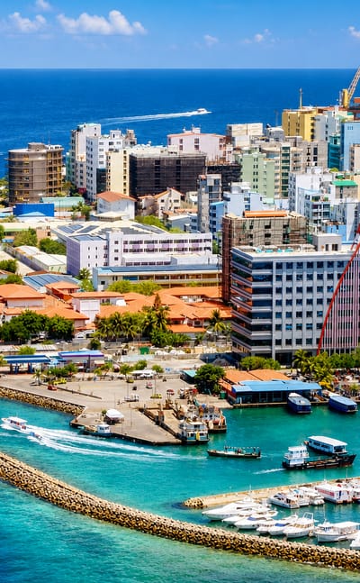 Aerial view of Malé, Maldives, its densely packed island capital ringed by turquoise lagoon and a boat-filled harbour
