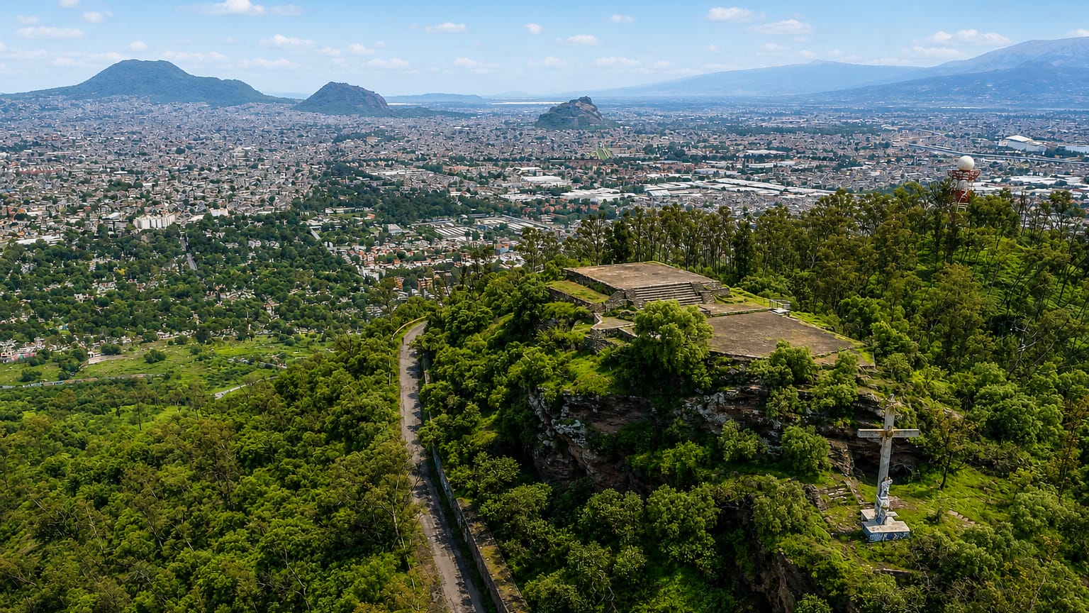 Cablebus cable cars over dense hillside housing and a park in Iztapalapa, Mexico City