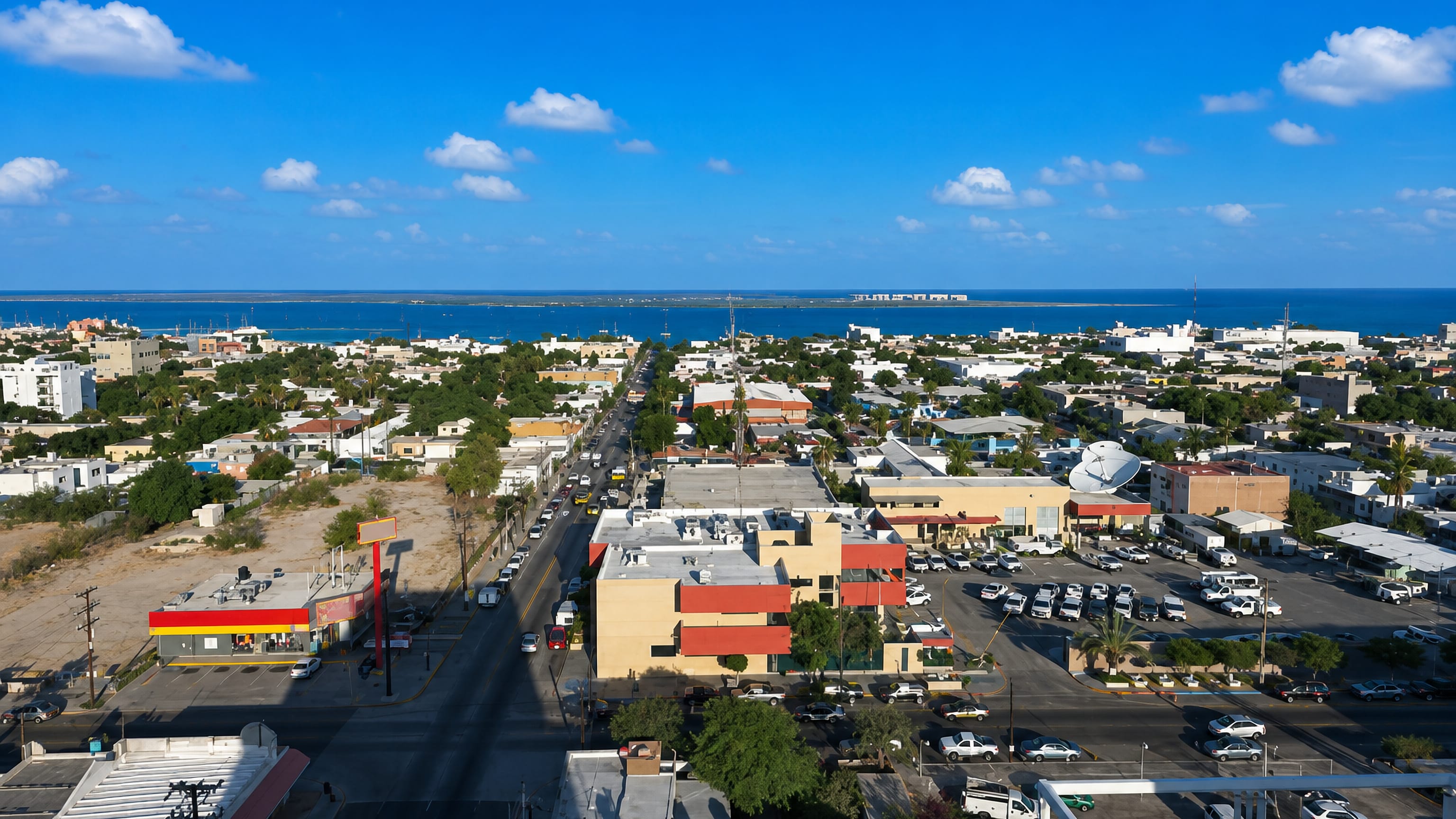 Aerial view across low-rise central La Paz, Mexico, to the blue Sea of Cortes bay and its sandy peninsula
