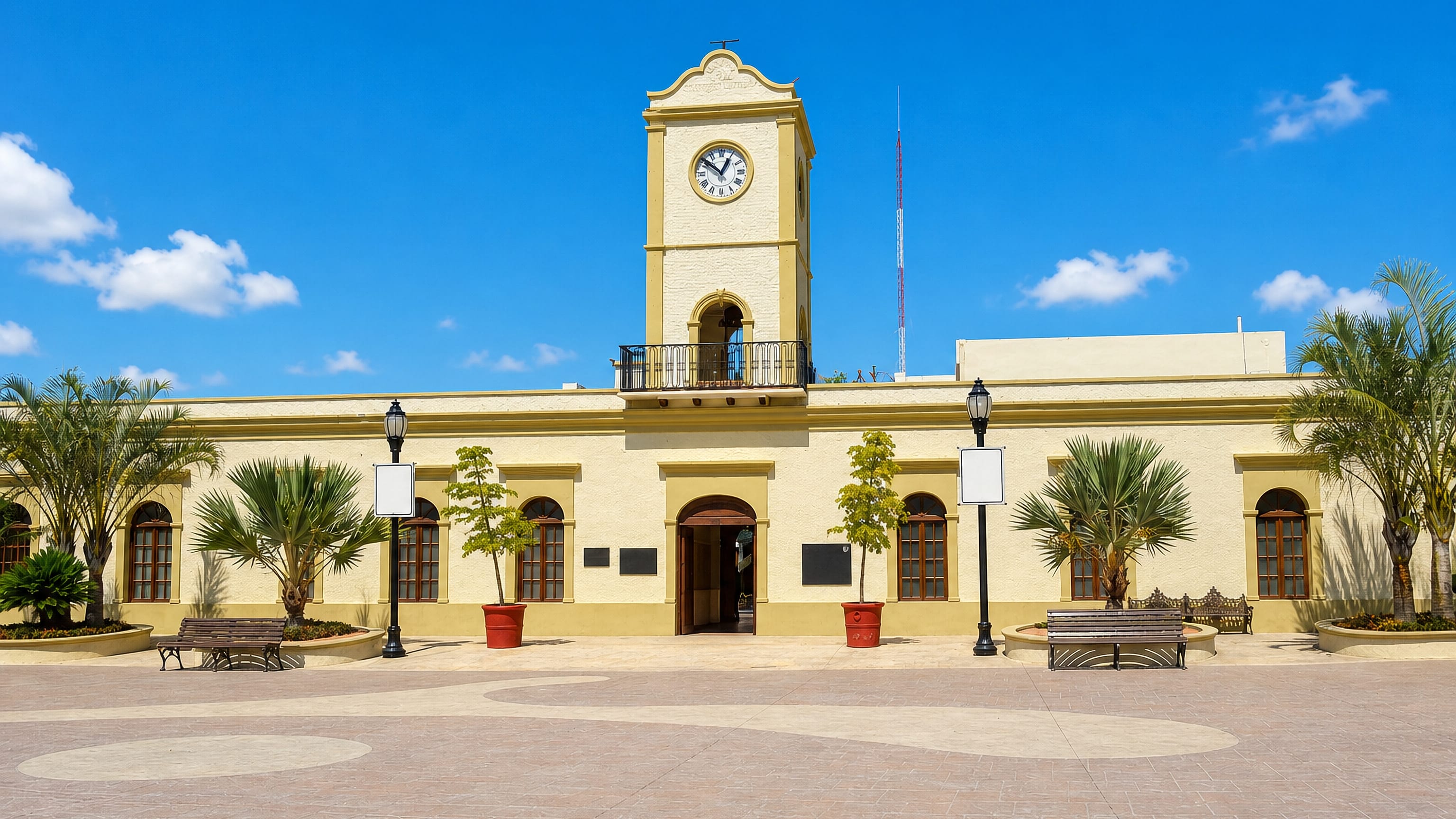 Yellow colonial town hall and its clock tower on the palm-lined main plaza of San Jose del Cabo, Mexico.