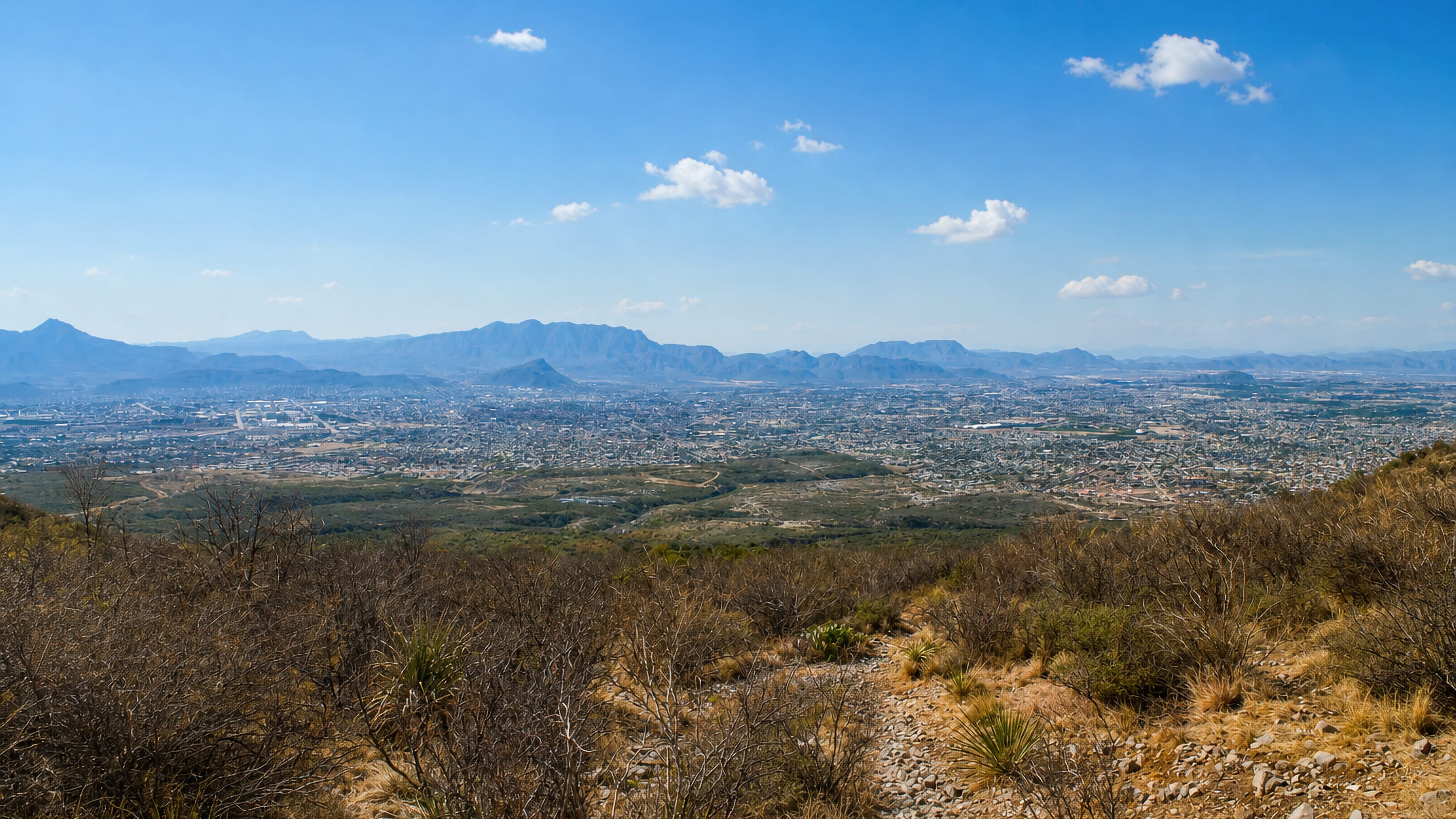 Saltillo spreading below the dry scrub slopes of the Sierra de Zapalinamé under a wide blue Coahuila sky.