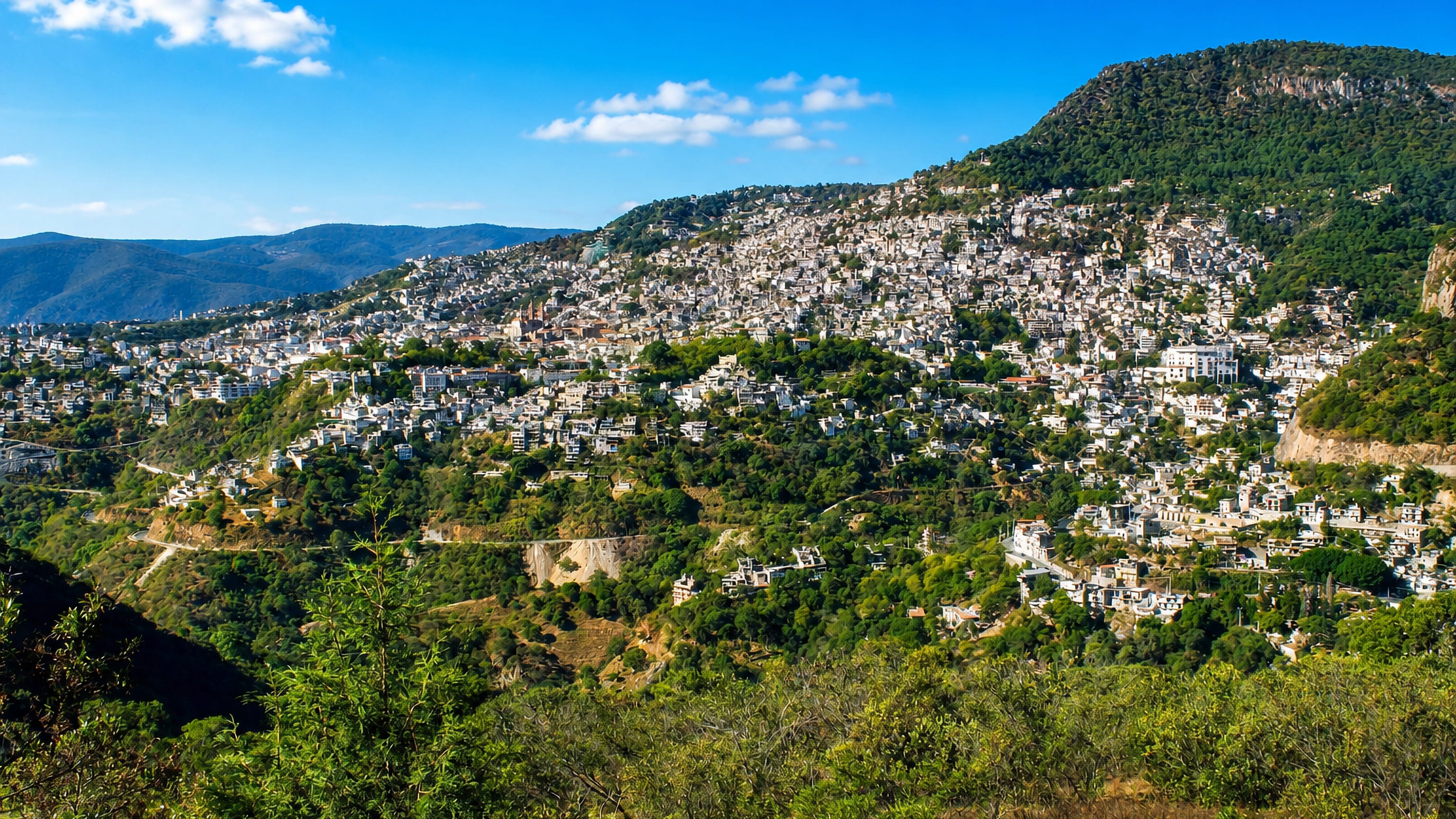 Whitewashed houses of Taxco de Alarcón, Mexico, spilling down forested hillsides in the Guerrero sierra.