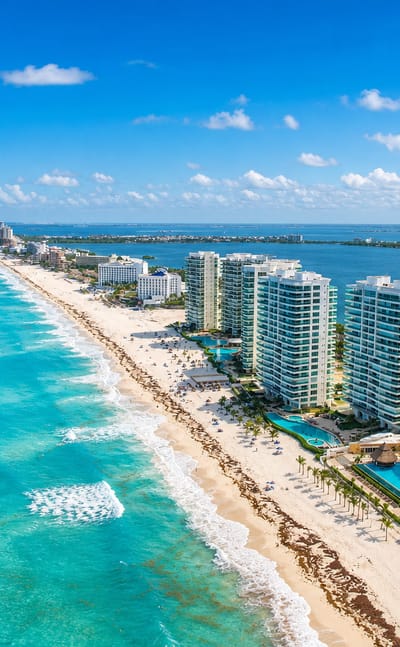 Cancún's Hotel Zone barrier island with beachfront resorts between the turquoise Caribbean and the lagoon