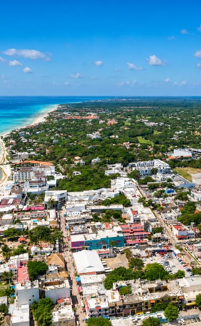 Aerial view of Playa del Carmen's turquoise Caribbean shoreline, white-sand beach, pier and low-rise town.