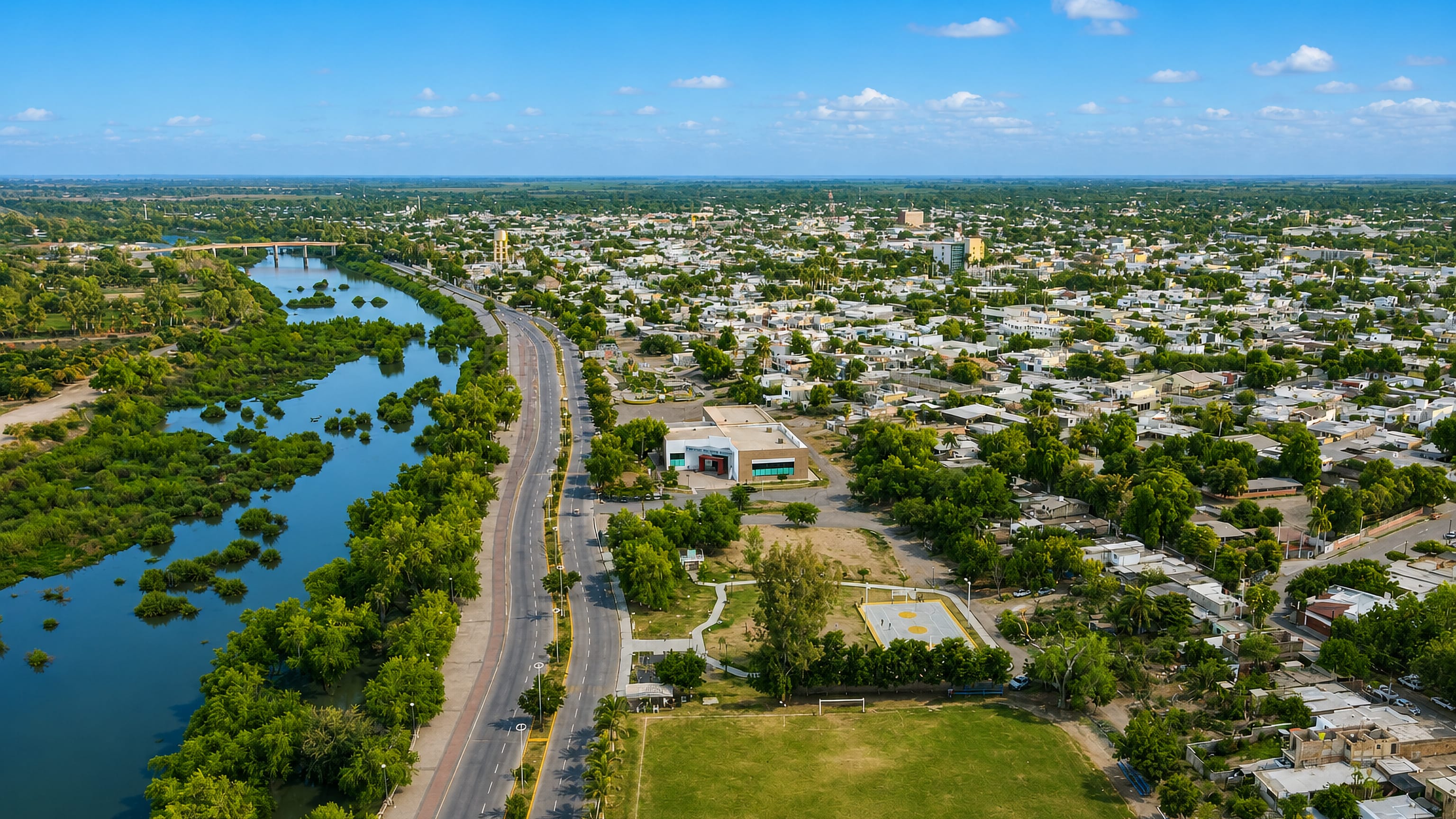 Aerial view of Guasave, Sinaloa, spread along the Rio Sinaloa beside a tree-lined boulevard.