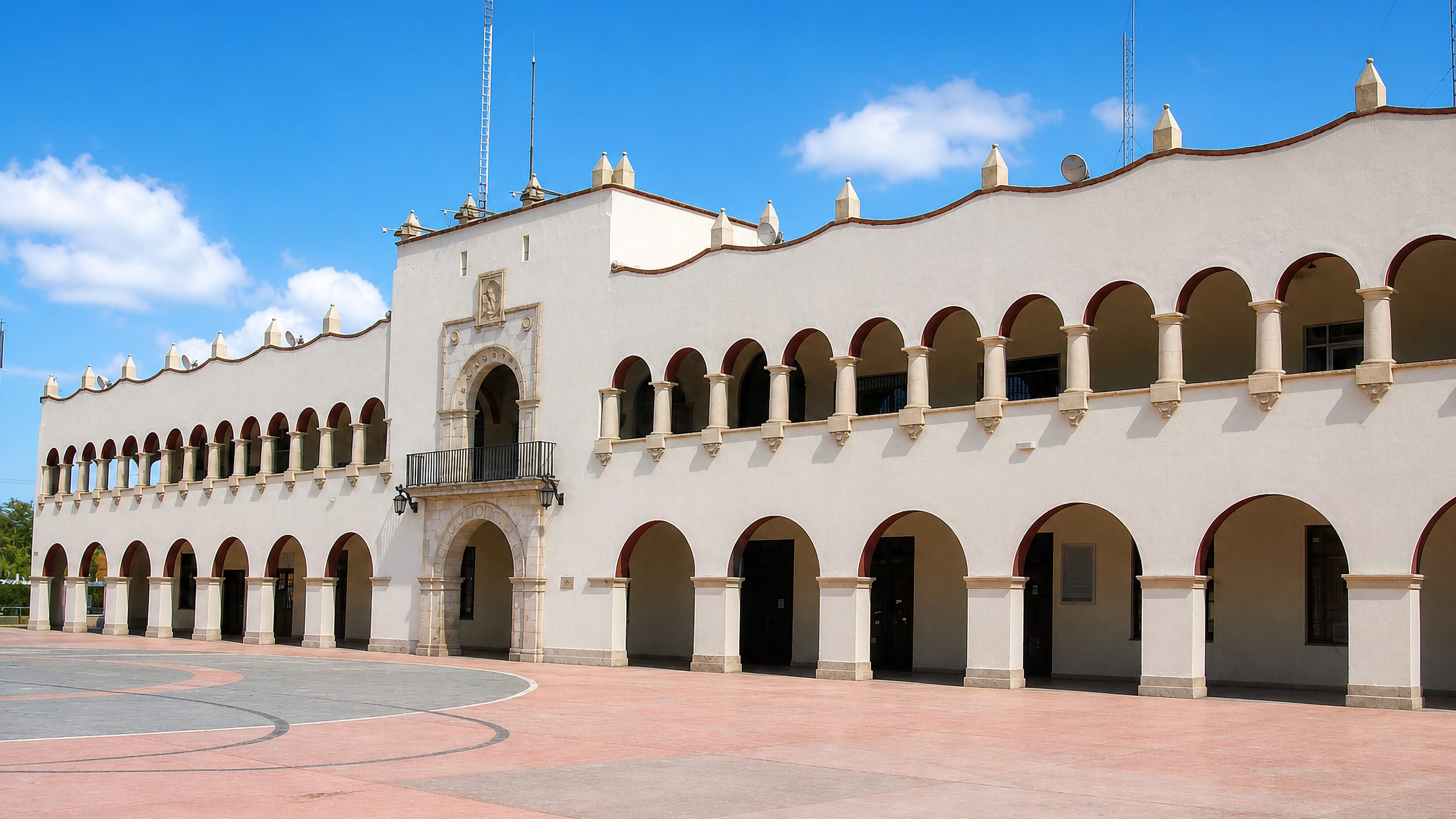 Arcaded white colonial-style civic palace on an empty paved plaza in Nuevo Laredo, Tamaulipas.
