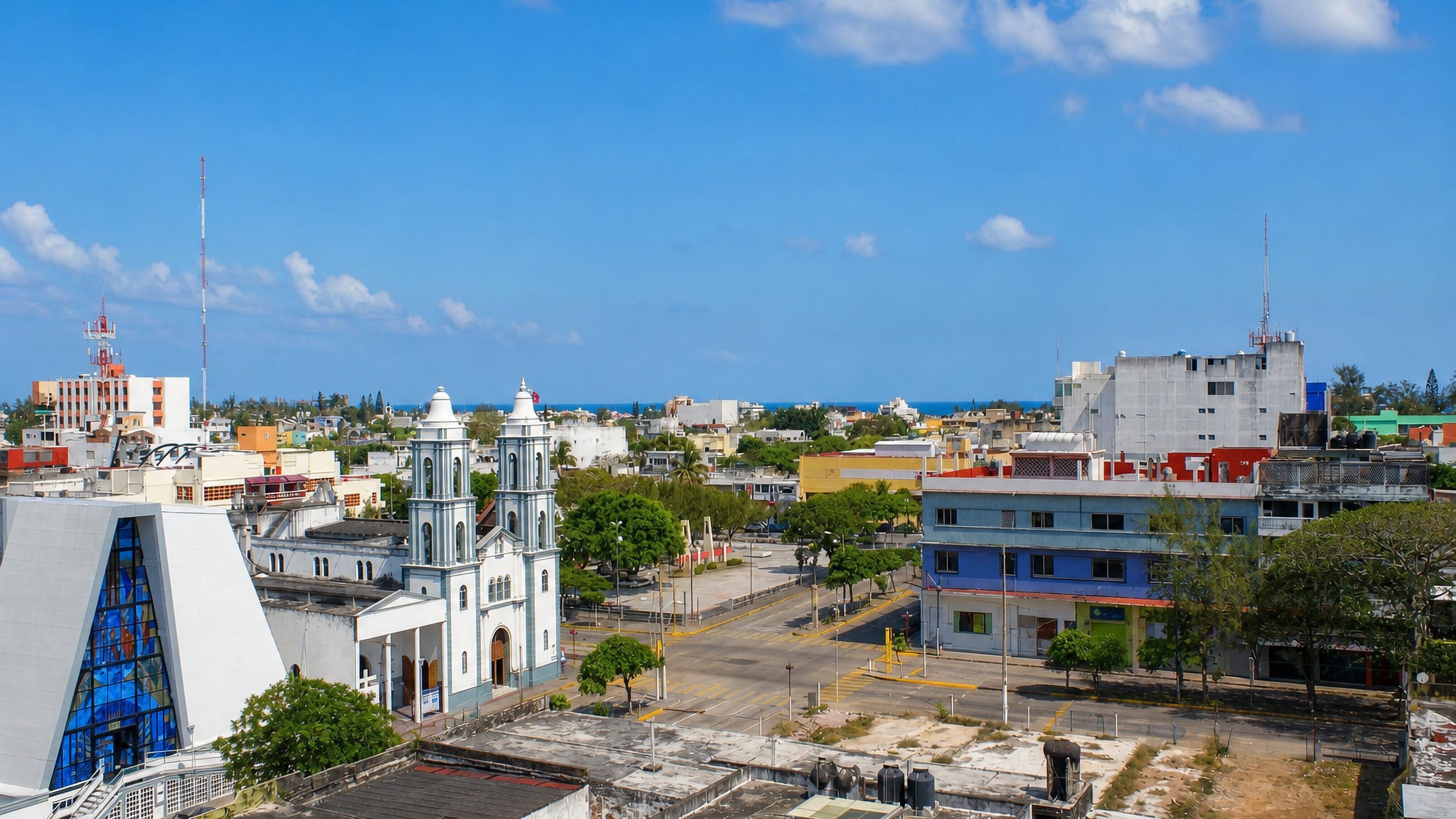 Twin-towered church and rooftops of Coatzacoalcos with the Gulf of Mexico on the horizon.
