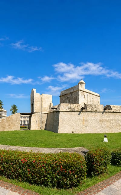 The stone Baluarte de Santiago fort and palm-lined plaza under a blue sky in Veracruz, Mexico